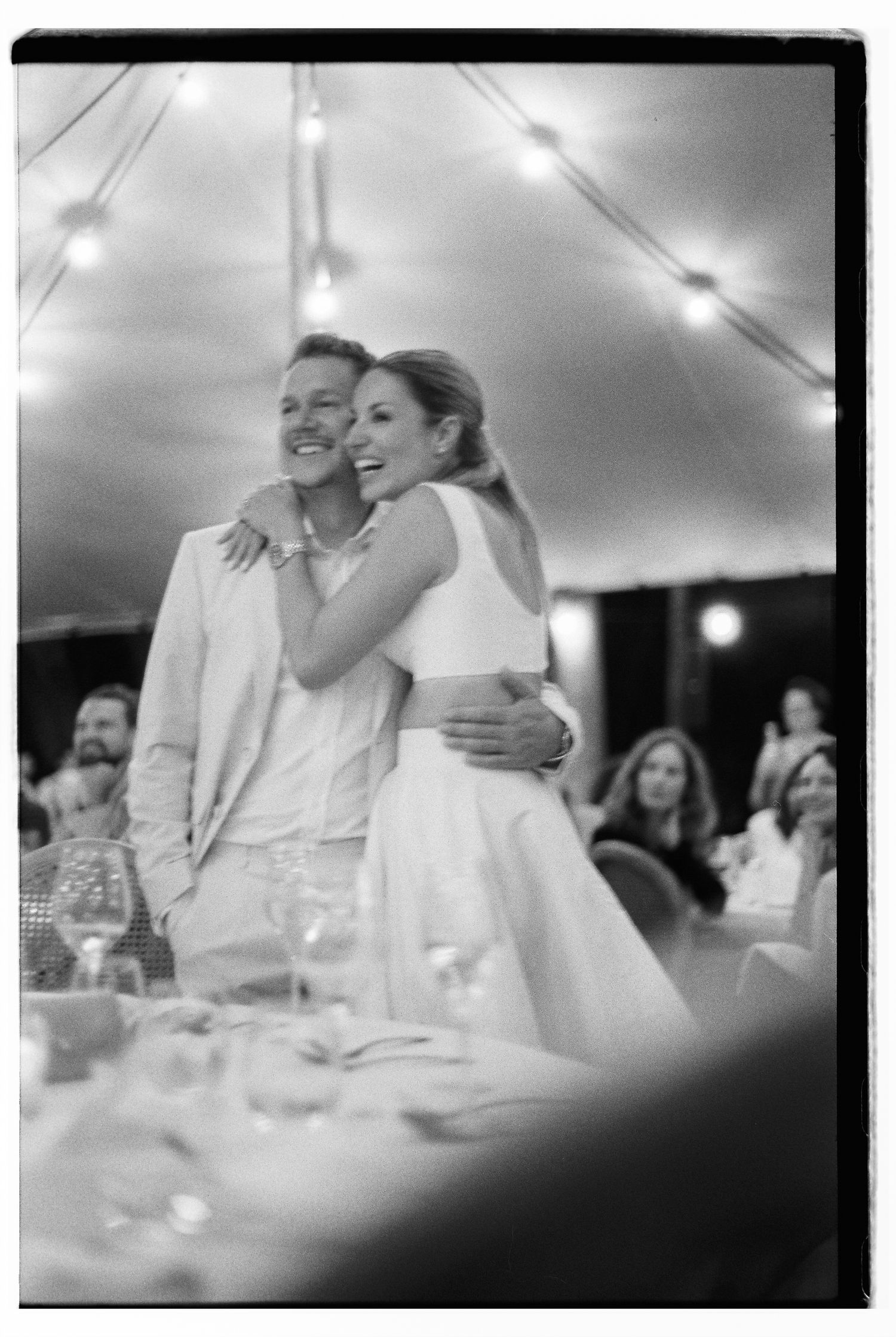 Black and white candid photos capture emotional moments during a wedding reception.