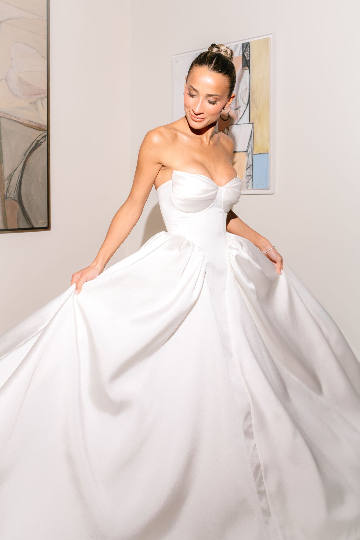 A series of photos showing a bride in a flowing white wedding gown twirling and posing against a light background.