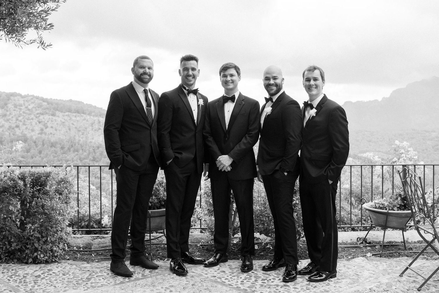 A sequence of black and white photos showing groomsmen posing together against scenic mountain backdrops.