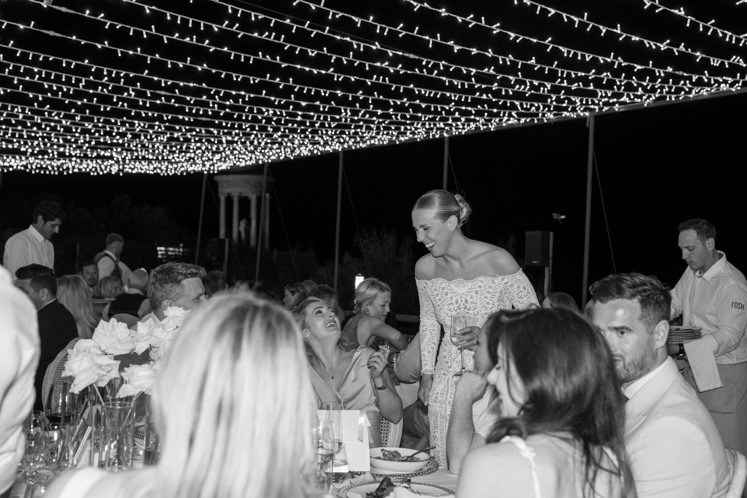 String lights illuminate an outdoor evening celebration venue.