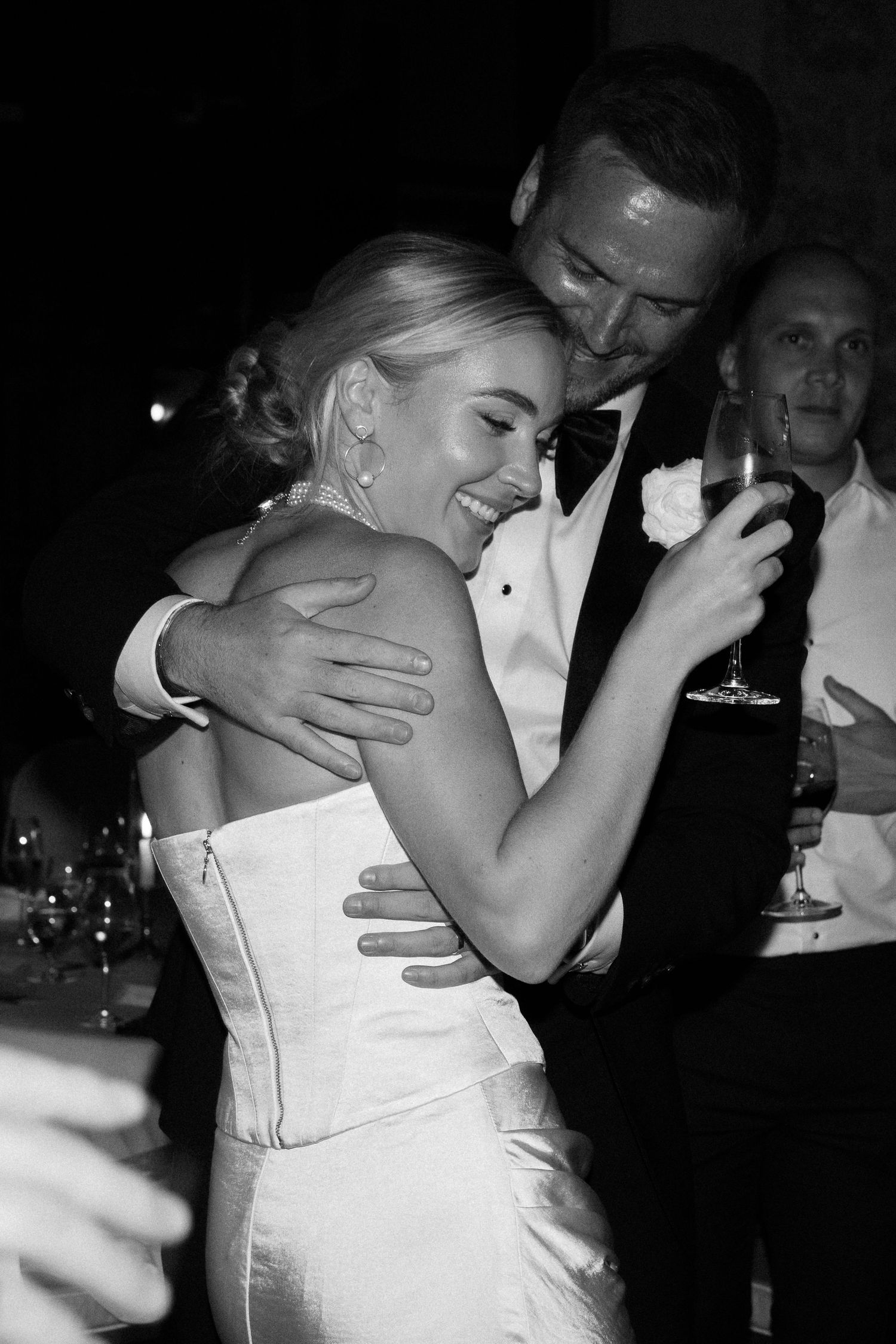 A couple in formal wedding attire share an intimate moment on the dance floor.
