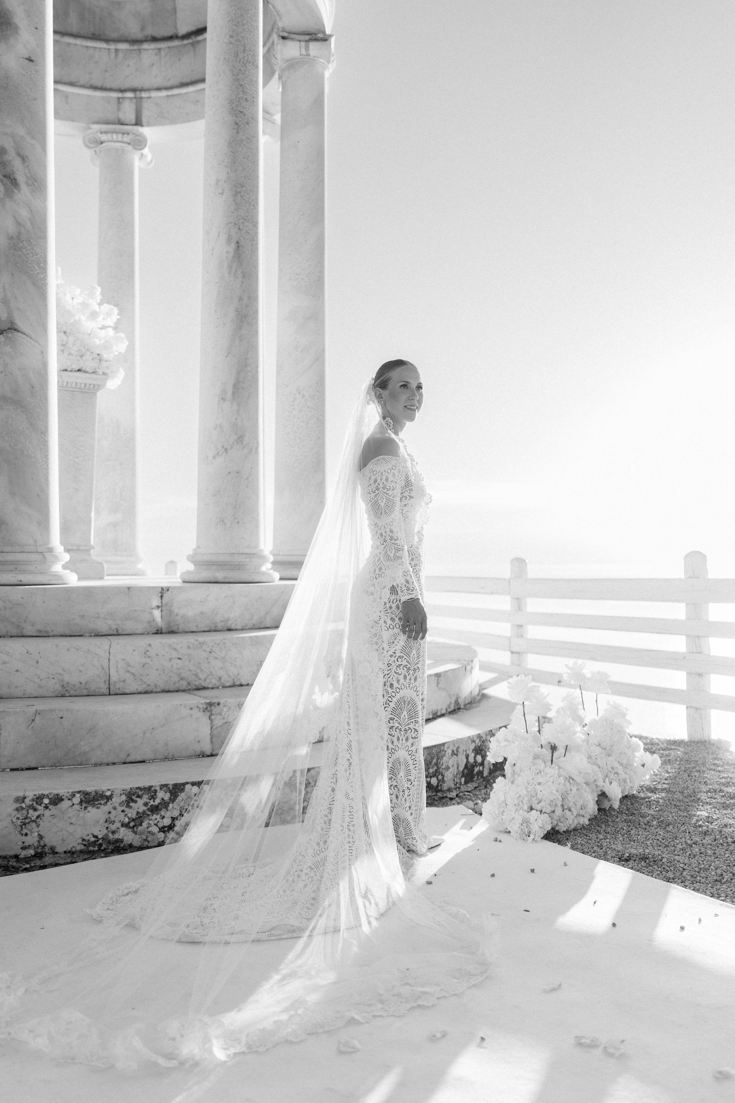 Dreamy black and white bridal portraits in columned pavilion with flowing train.