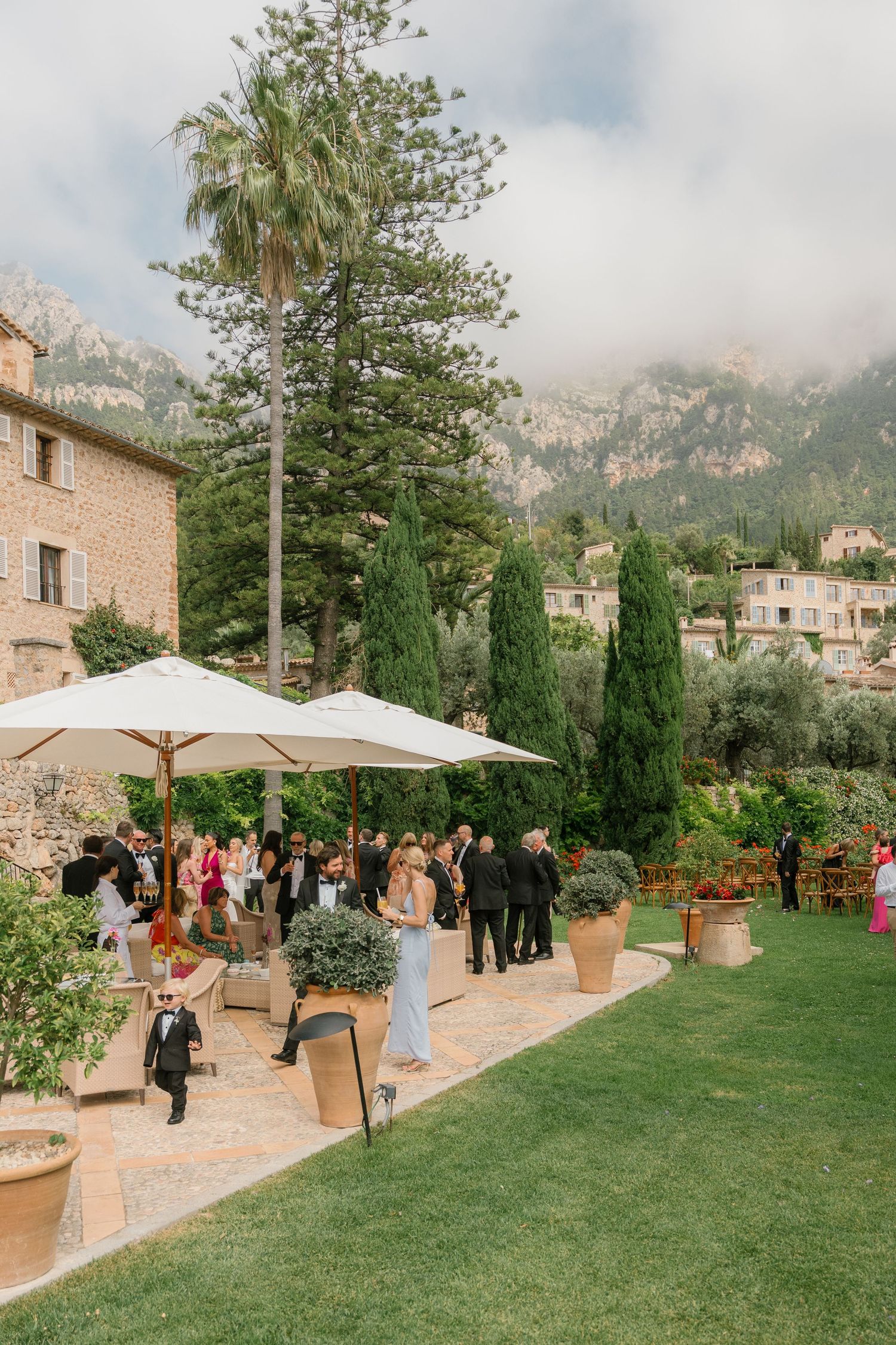 Outdoor wedding venue with mountain views featuring a stone house and manicured lawn.