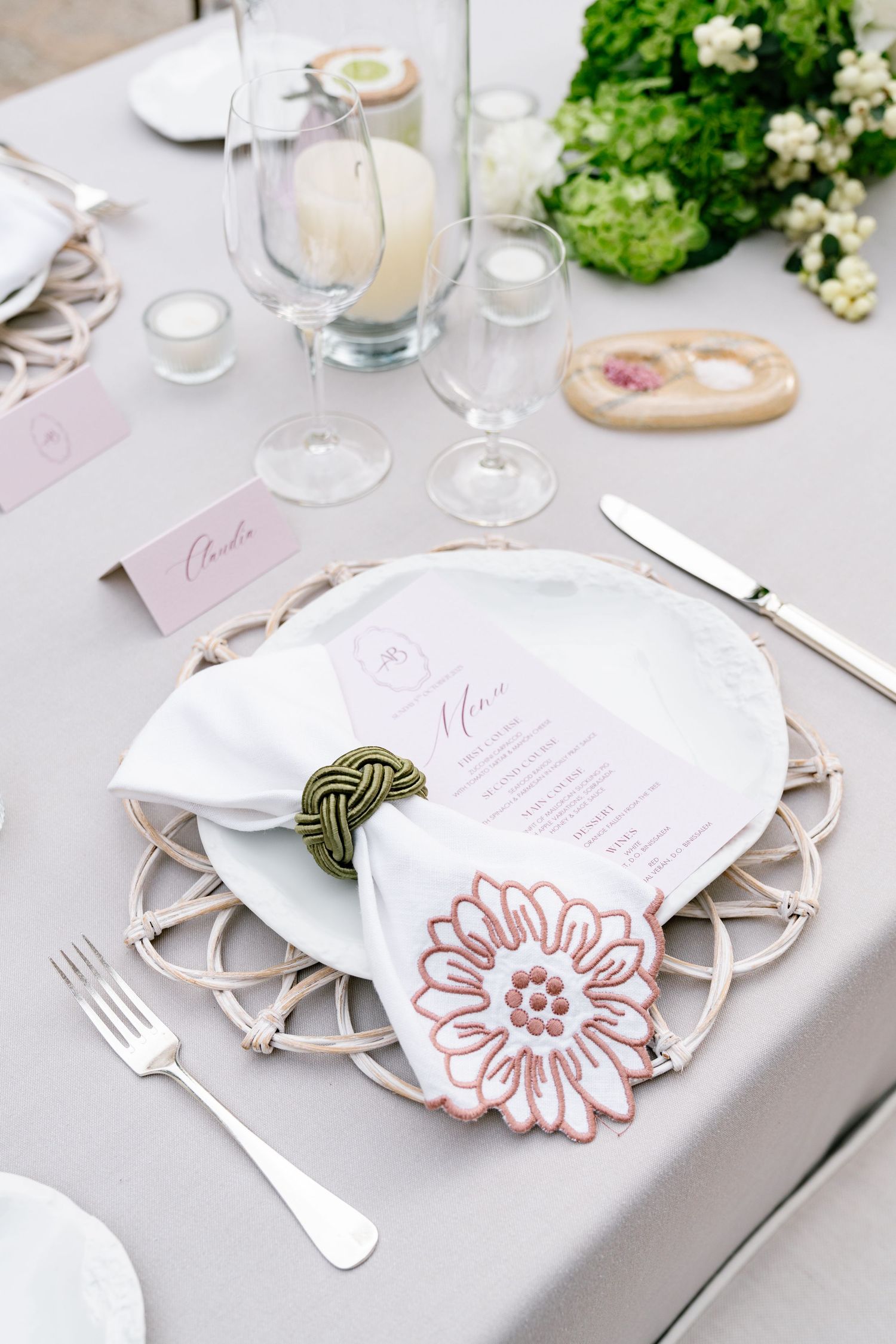 Elegant place setting with floral napkin detail and delicate menu card at wedding reception.