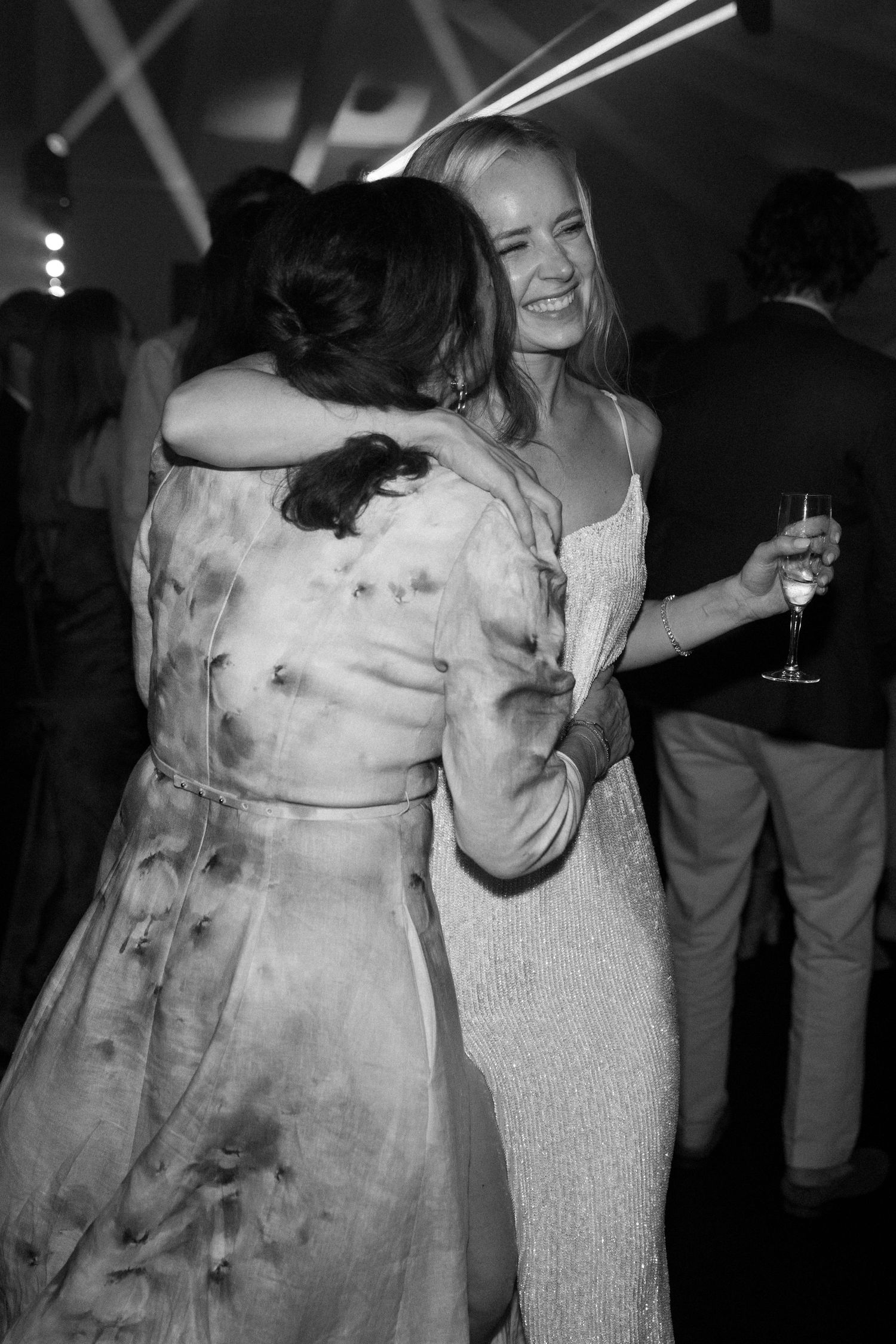 Wedding guests embrace during an emotional moment at the reception.