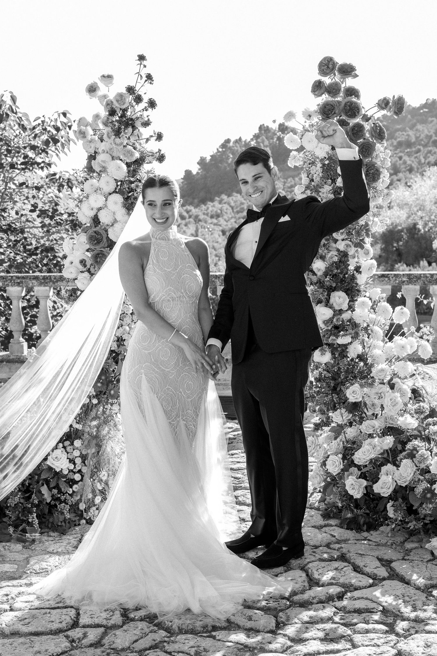 Black and white wedding portraits captured against a garden backdrop with flowing veil.