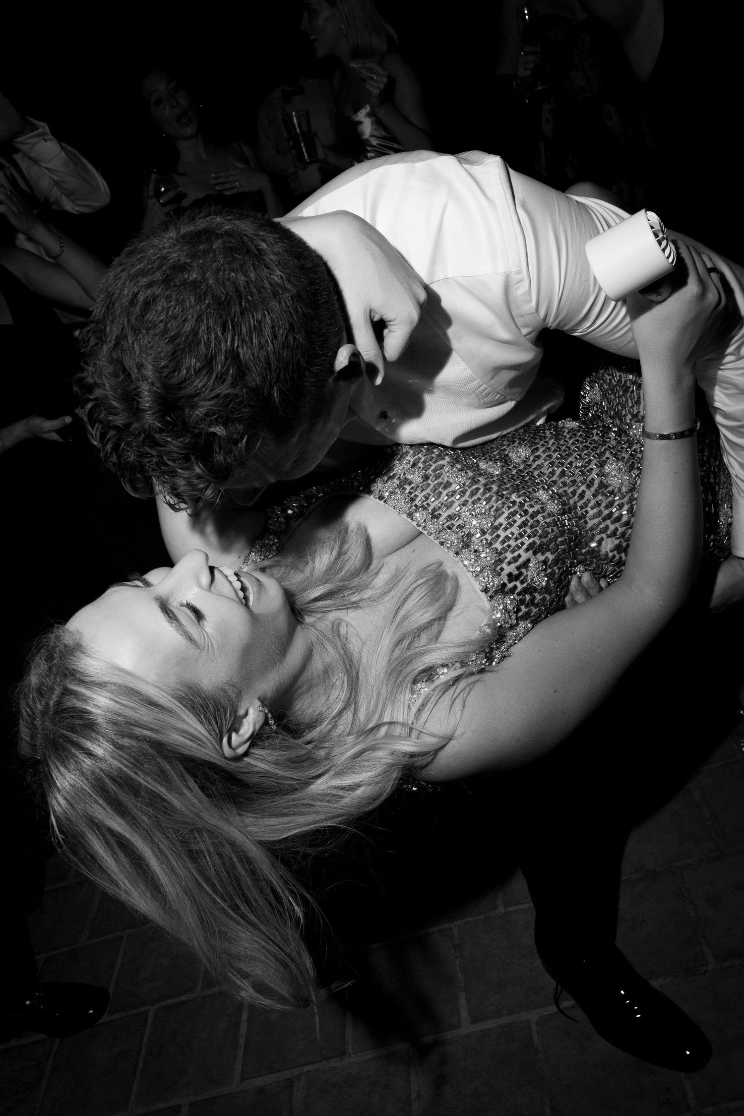 Black and white photo of a couple sharing a romantic dip dance on a crowded dance floor.