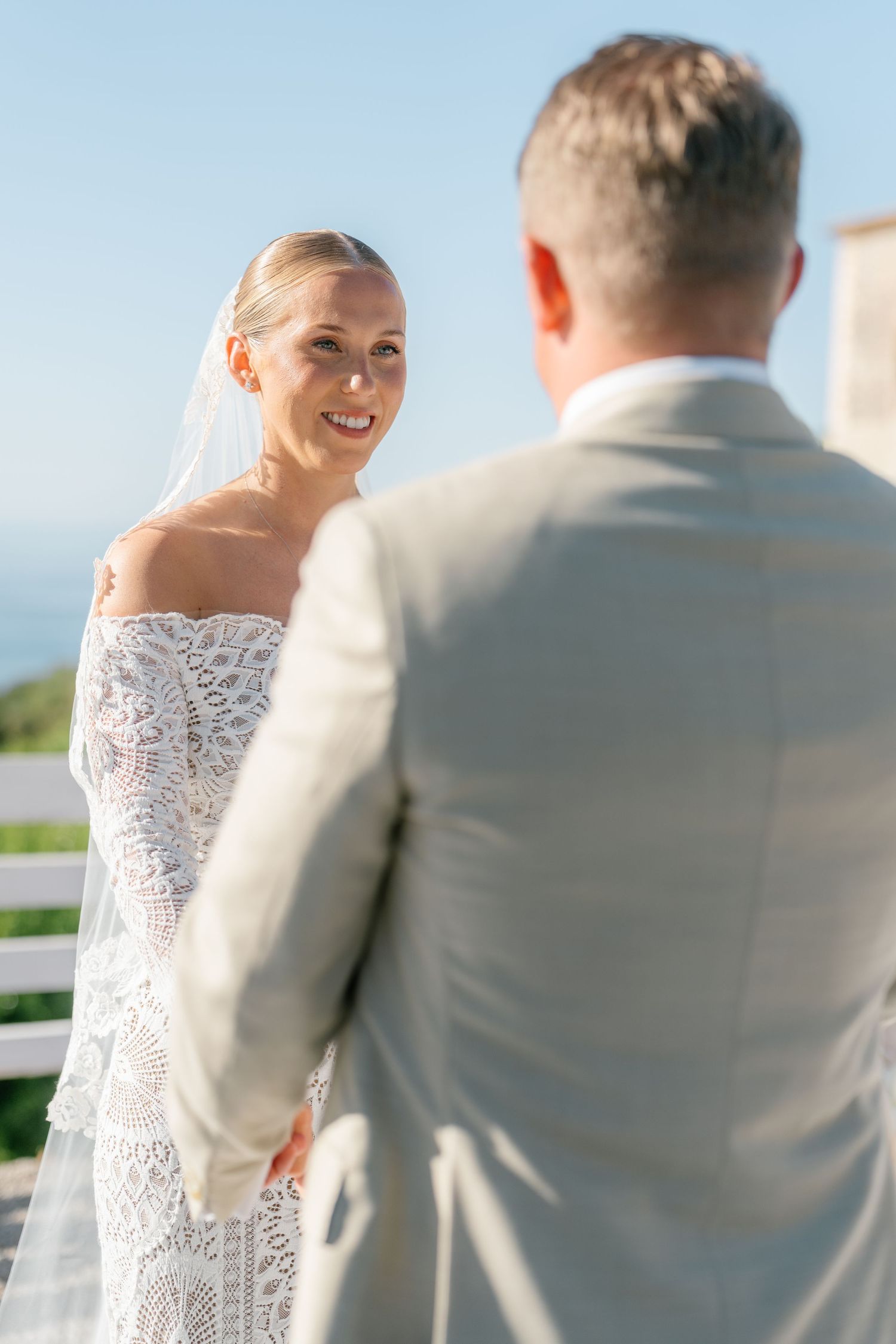 Intimate wedding ceremony moment against blue sky backdrop.