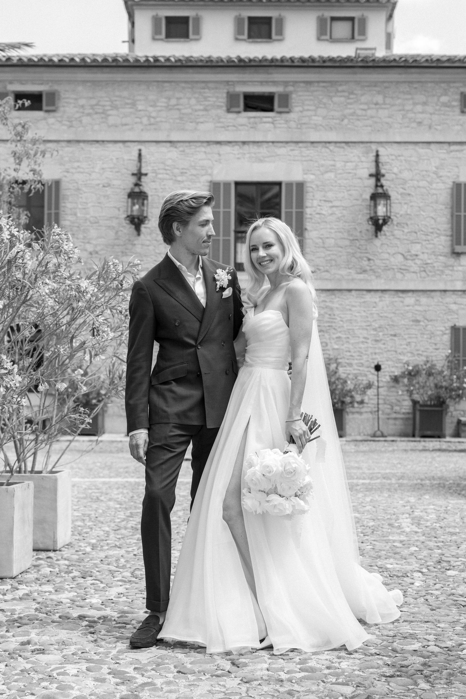 Newlyweds share tender moments in a rustic Mediterranean courtyard.