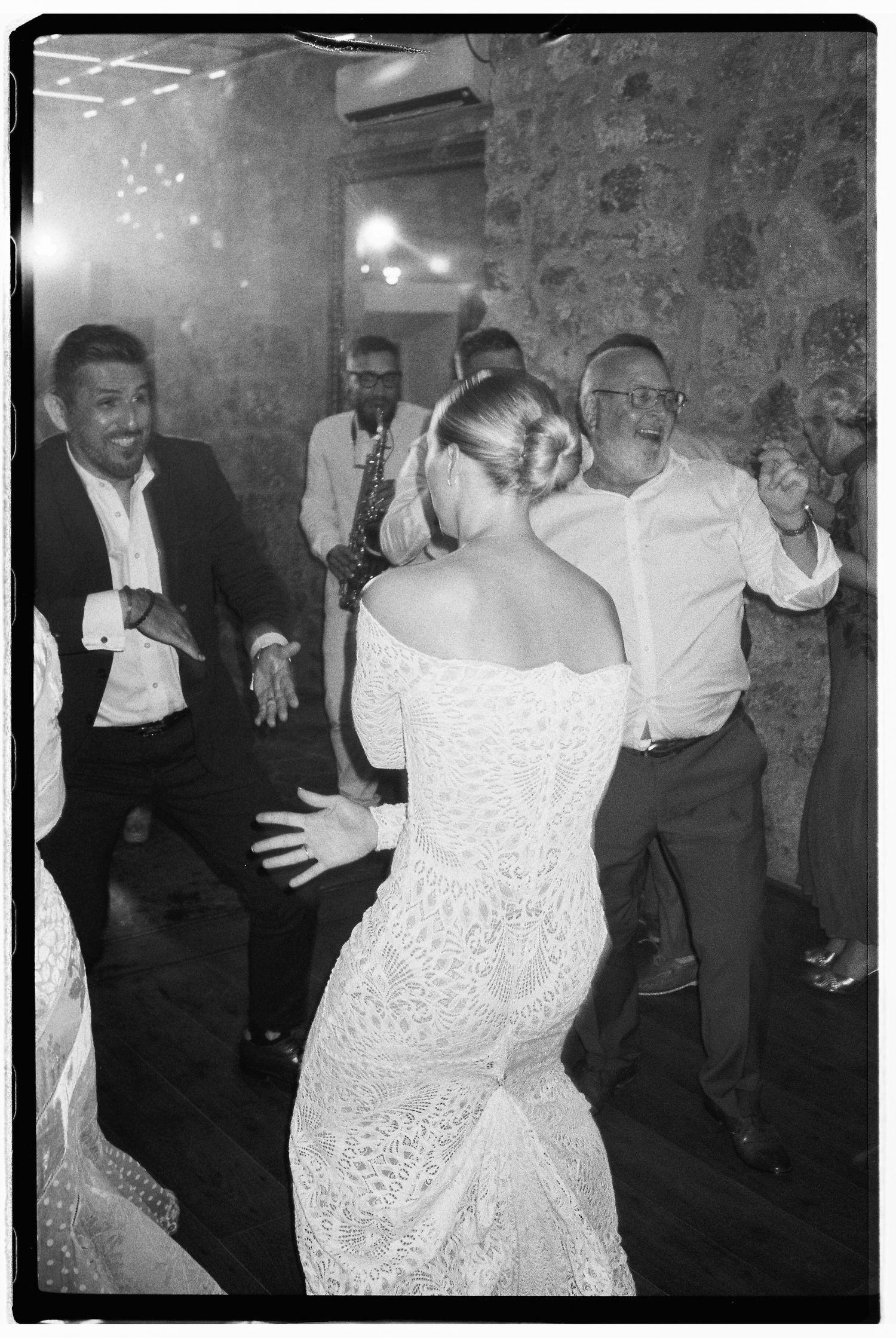 Black and white photos of wedding guests dancing and celebrating at a reception.