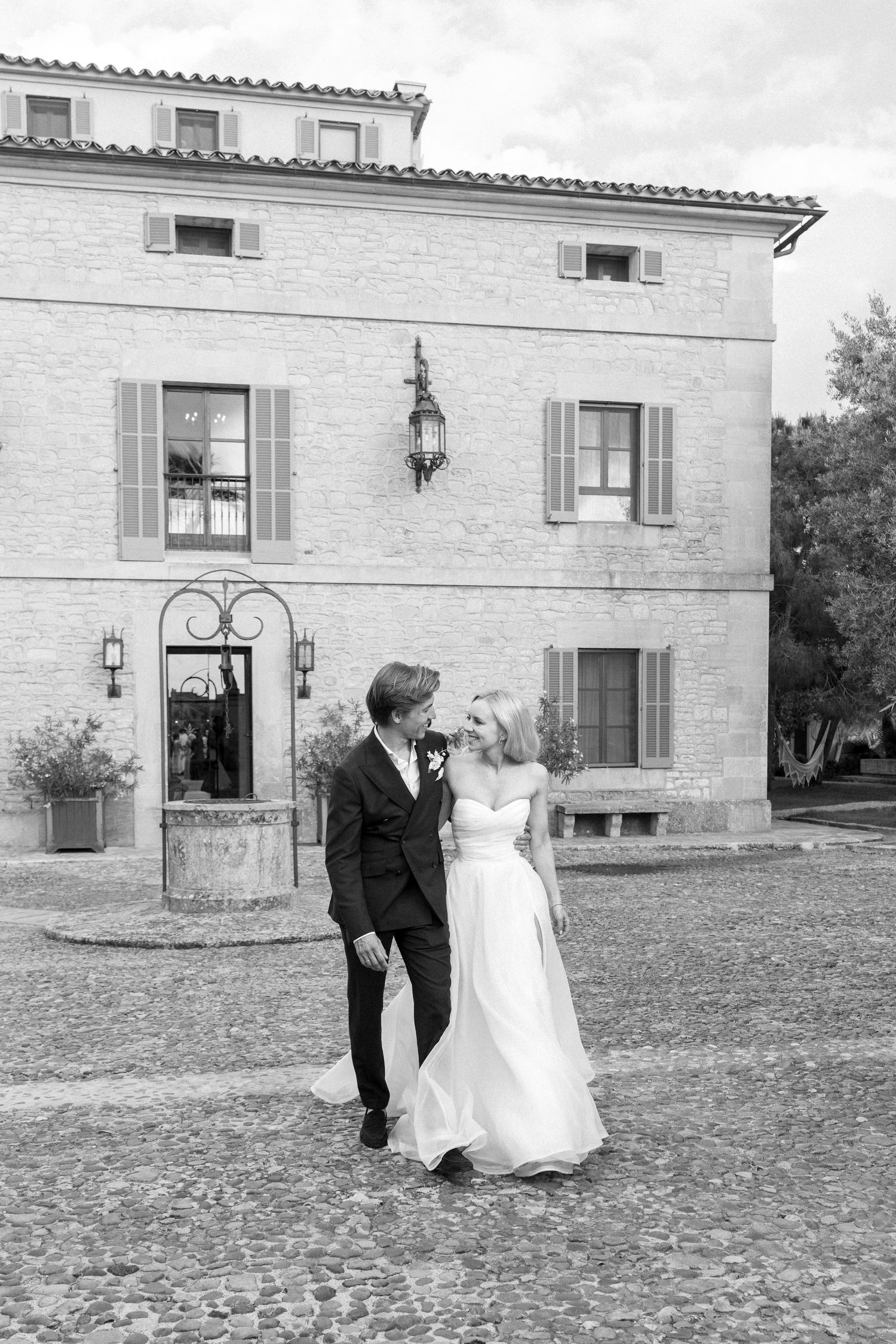 Couple walking outside a Mediterranean-style stone villa.
