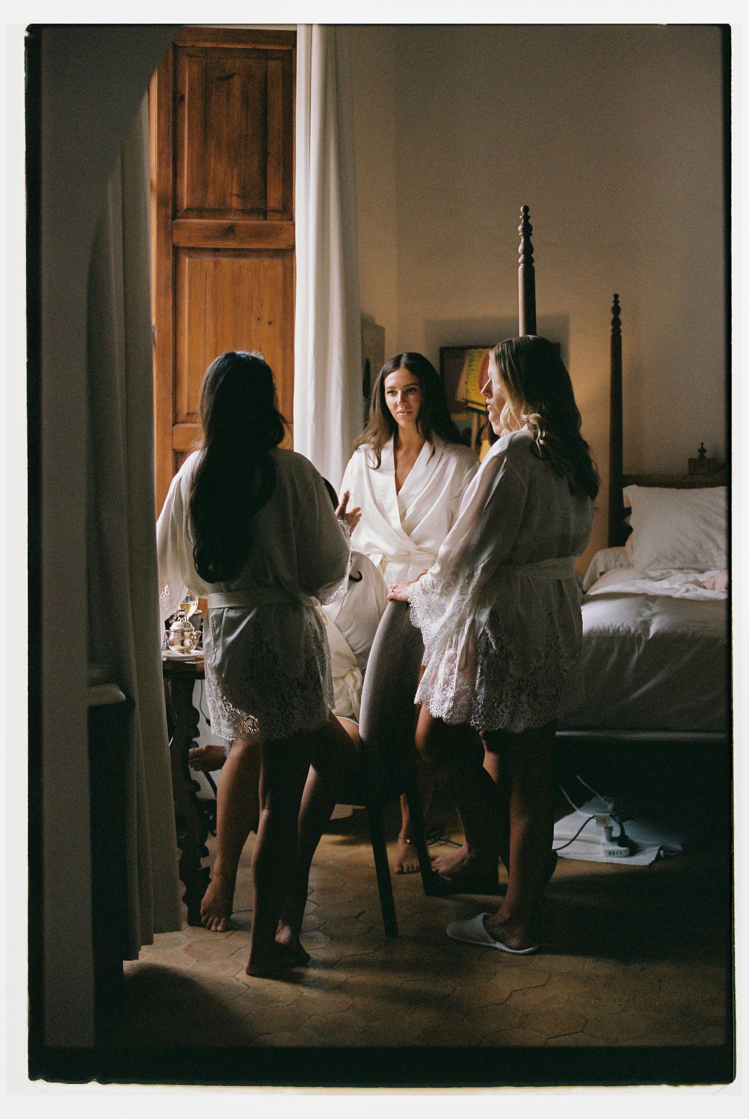 Group getting ready in white outfits in a rustic room interior.
