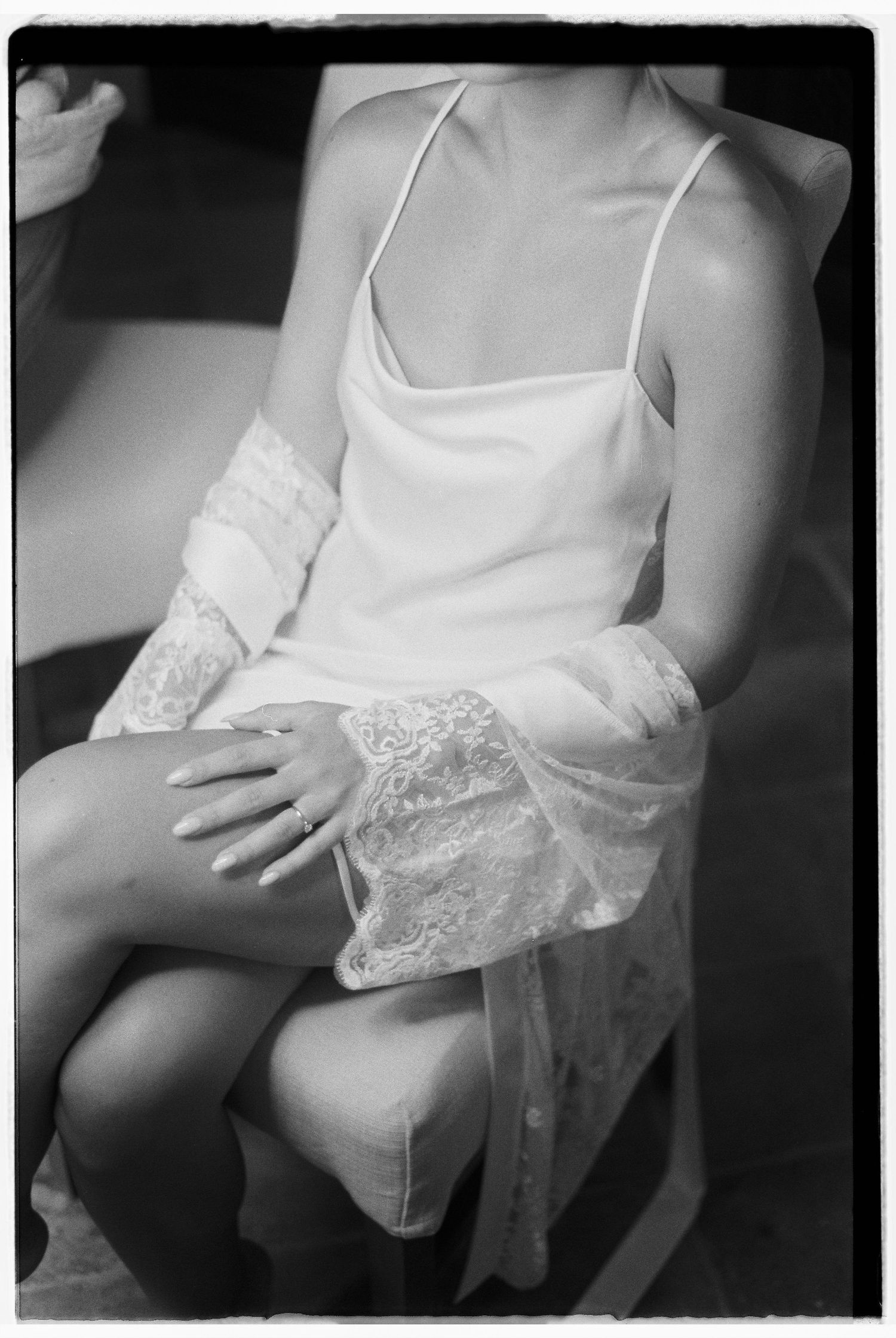 Intimate black and white detail shot of delicate lace wedding attire.