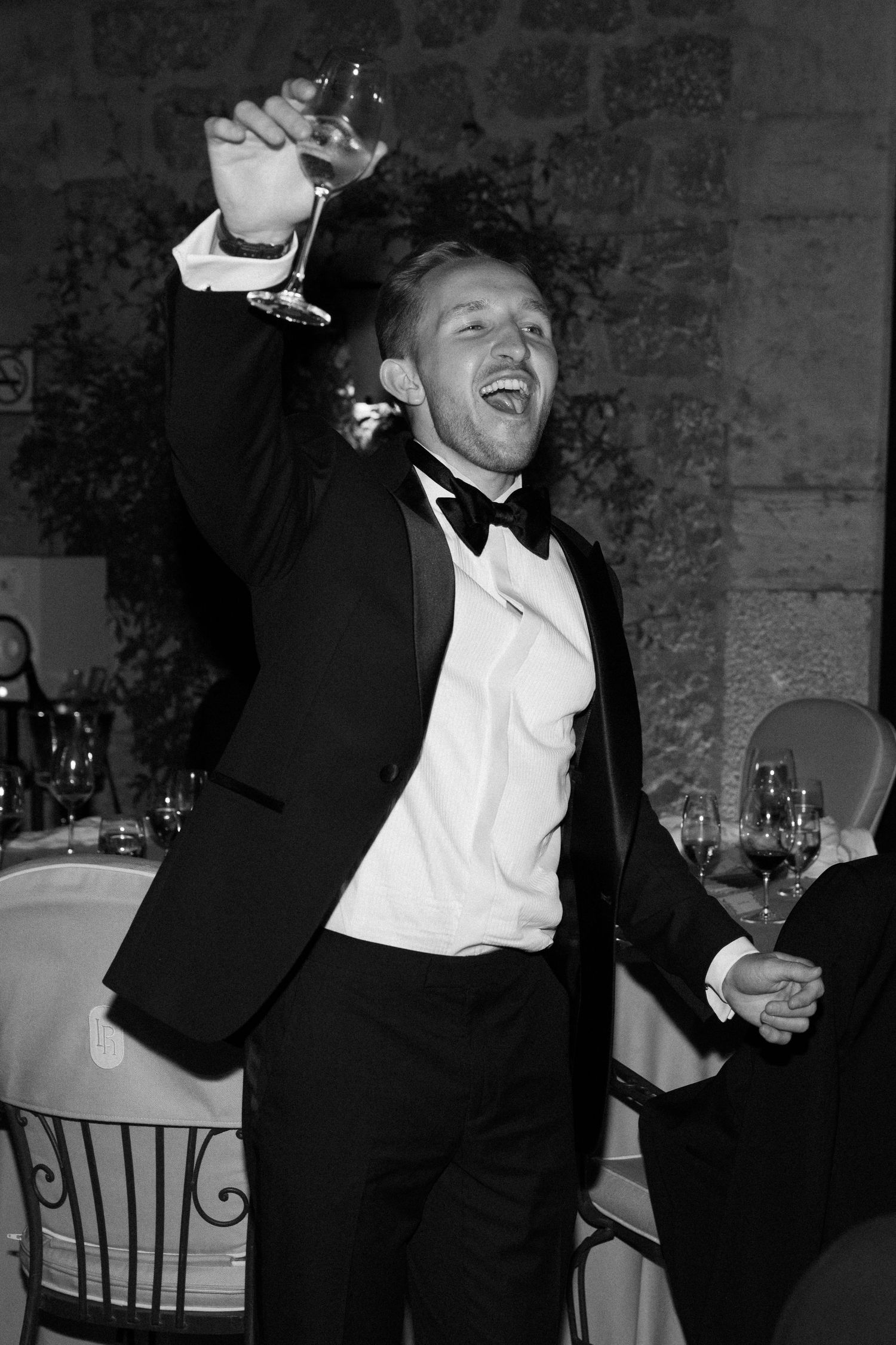 Wedding guests in formal attire dancing and celebrating at a reception.