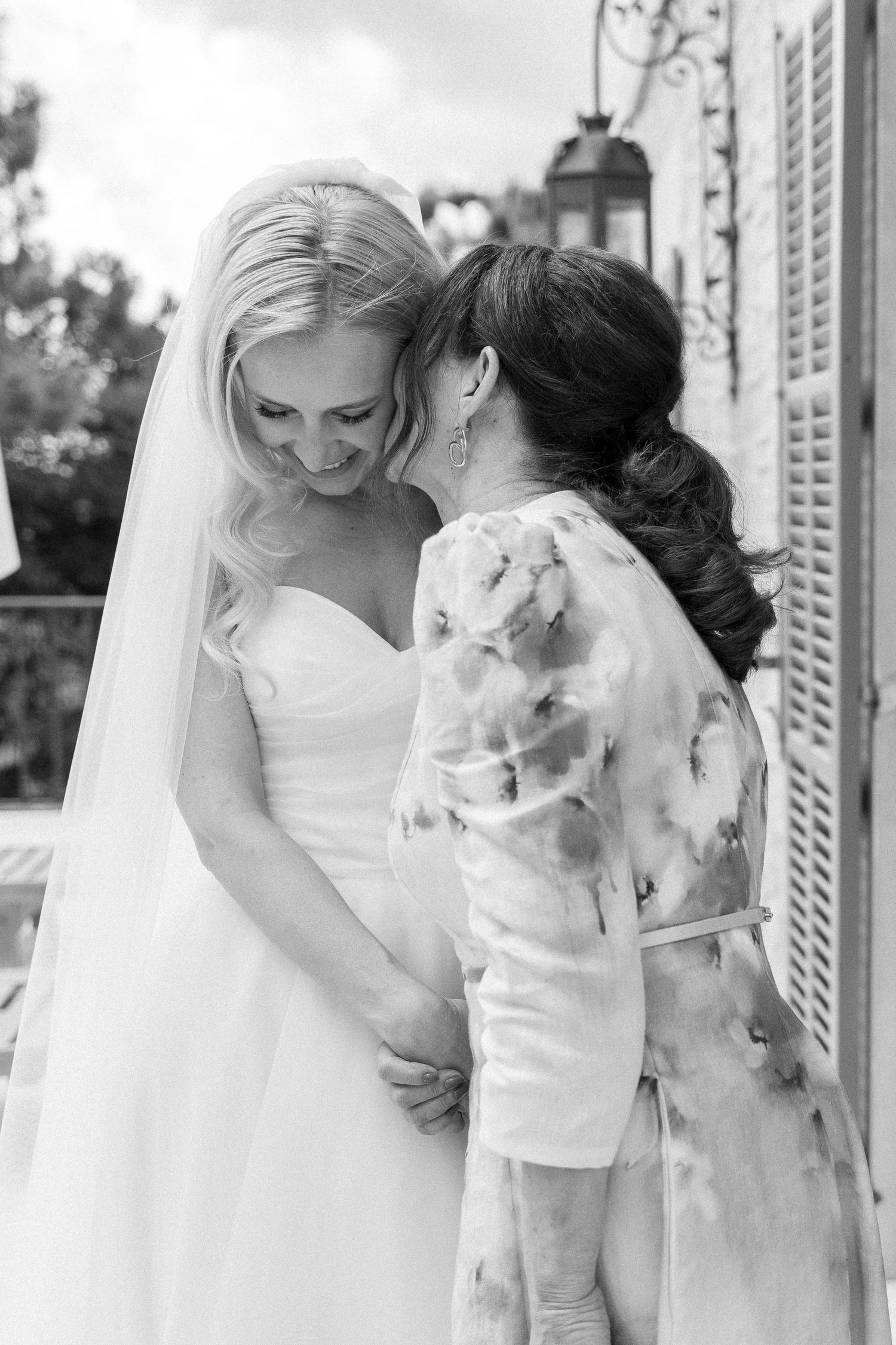 Candid emotional moments between bride and family members in white dresses.