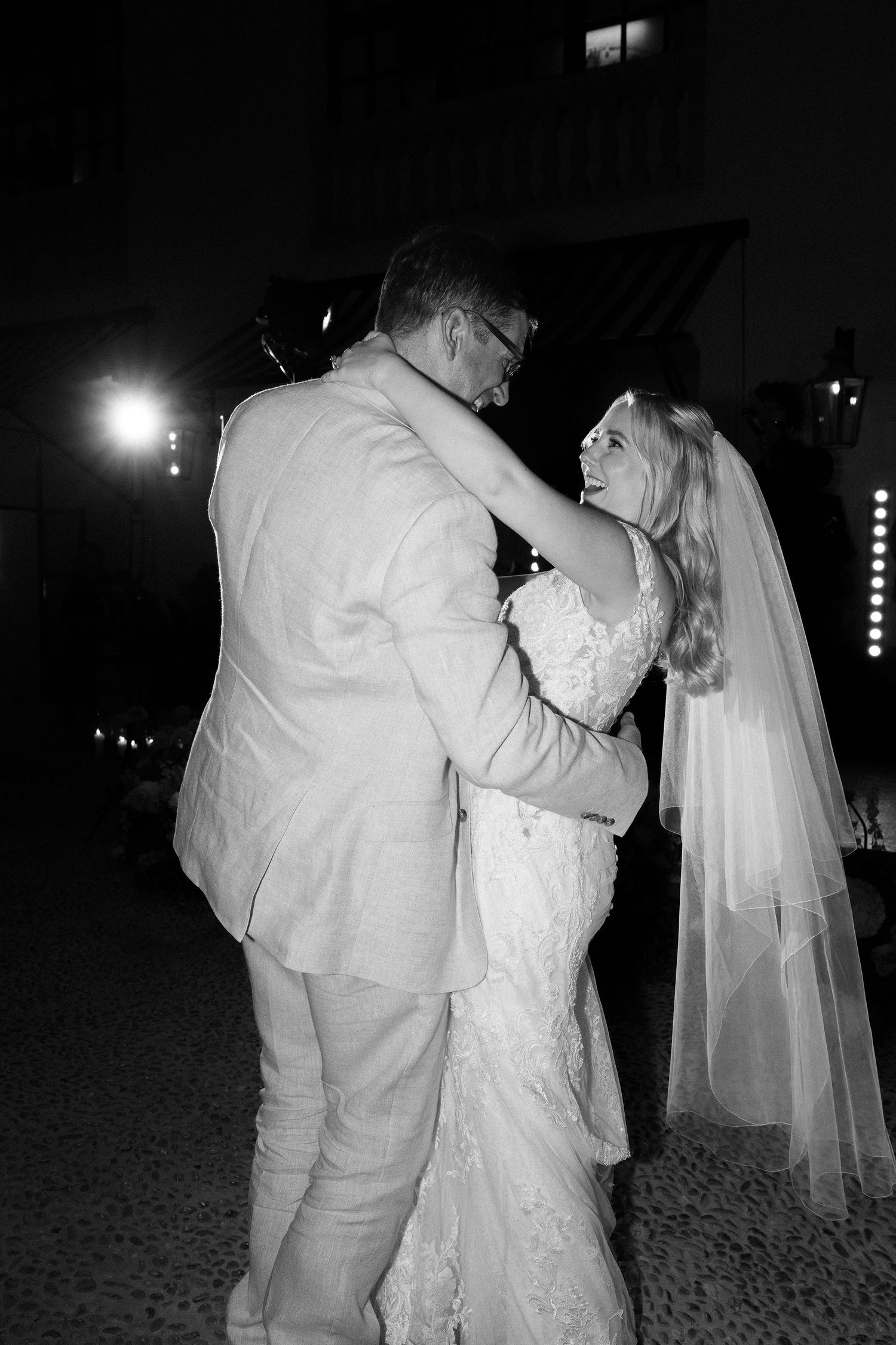Black and white photo of a couple dancing together at their wedding reception.