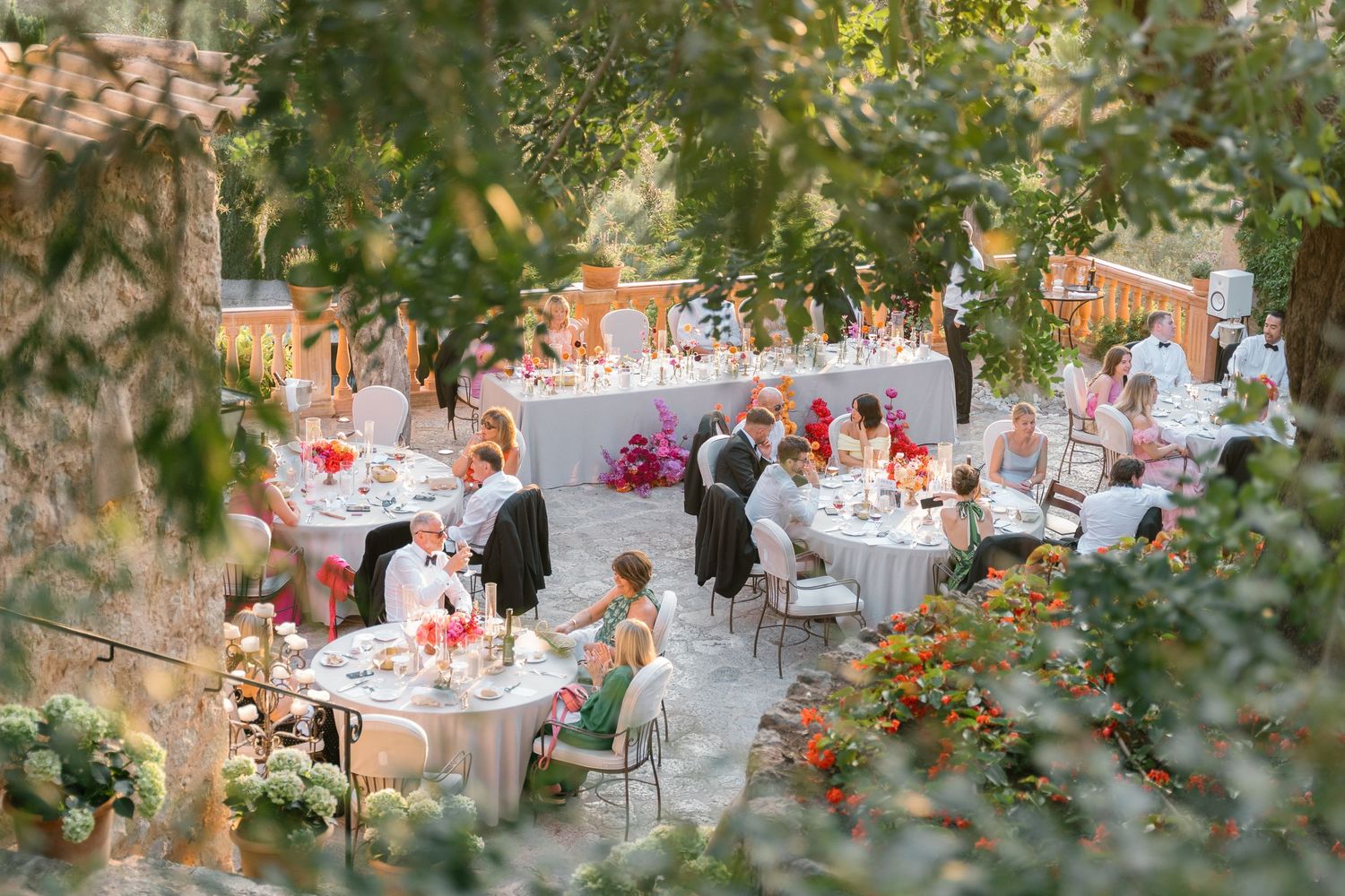 Elegant outdoor wedding reception tables decorated with floral centerpieces and place settings.