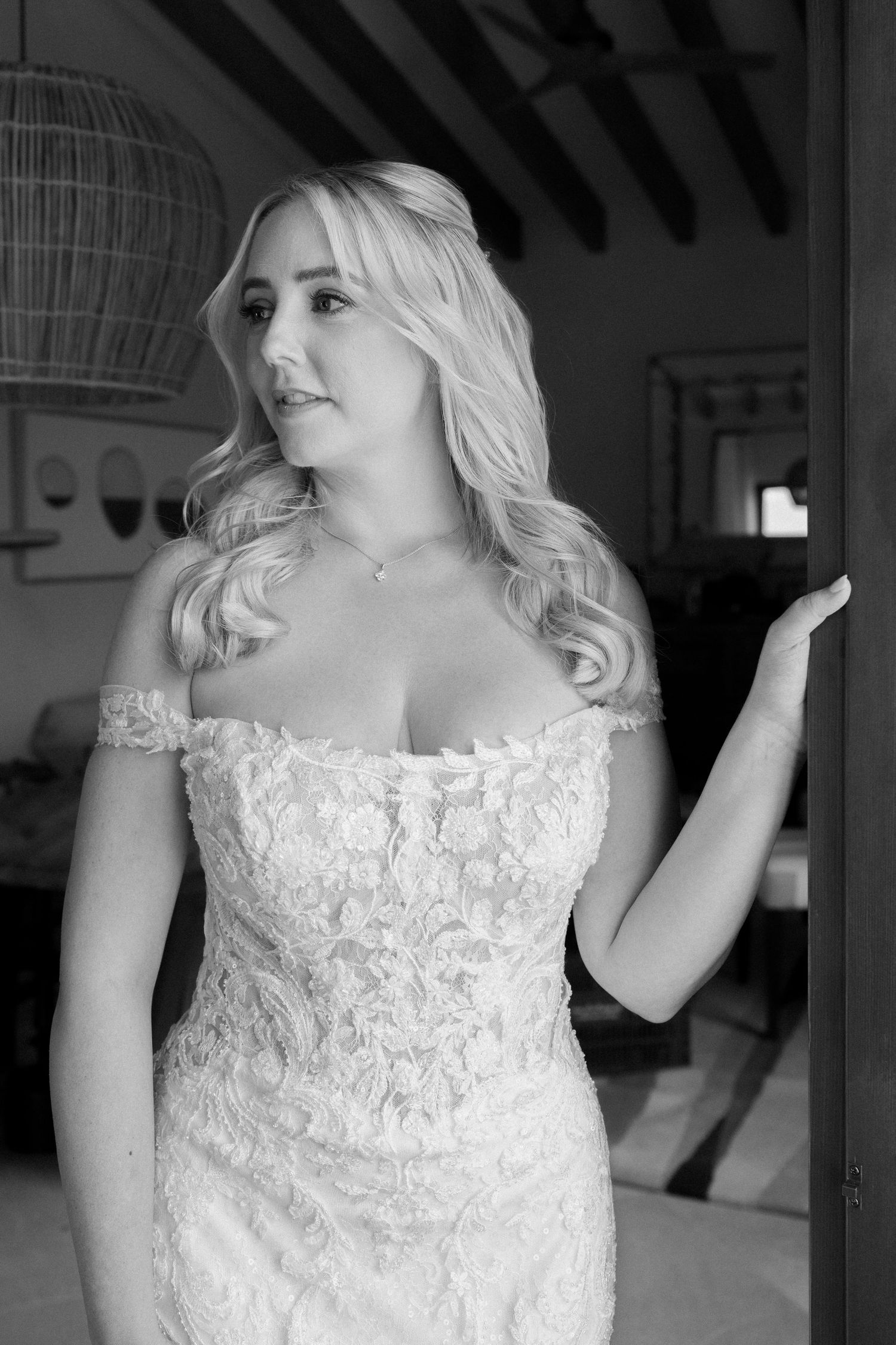 Elegant lace wedding dress detail in black and white photography.