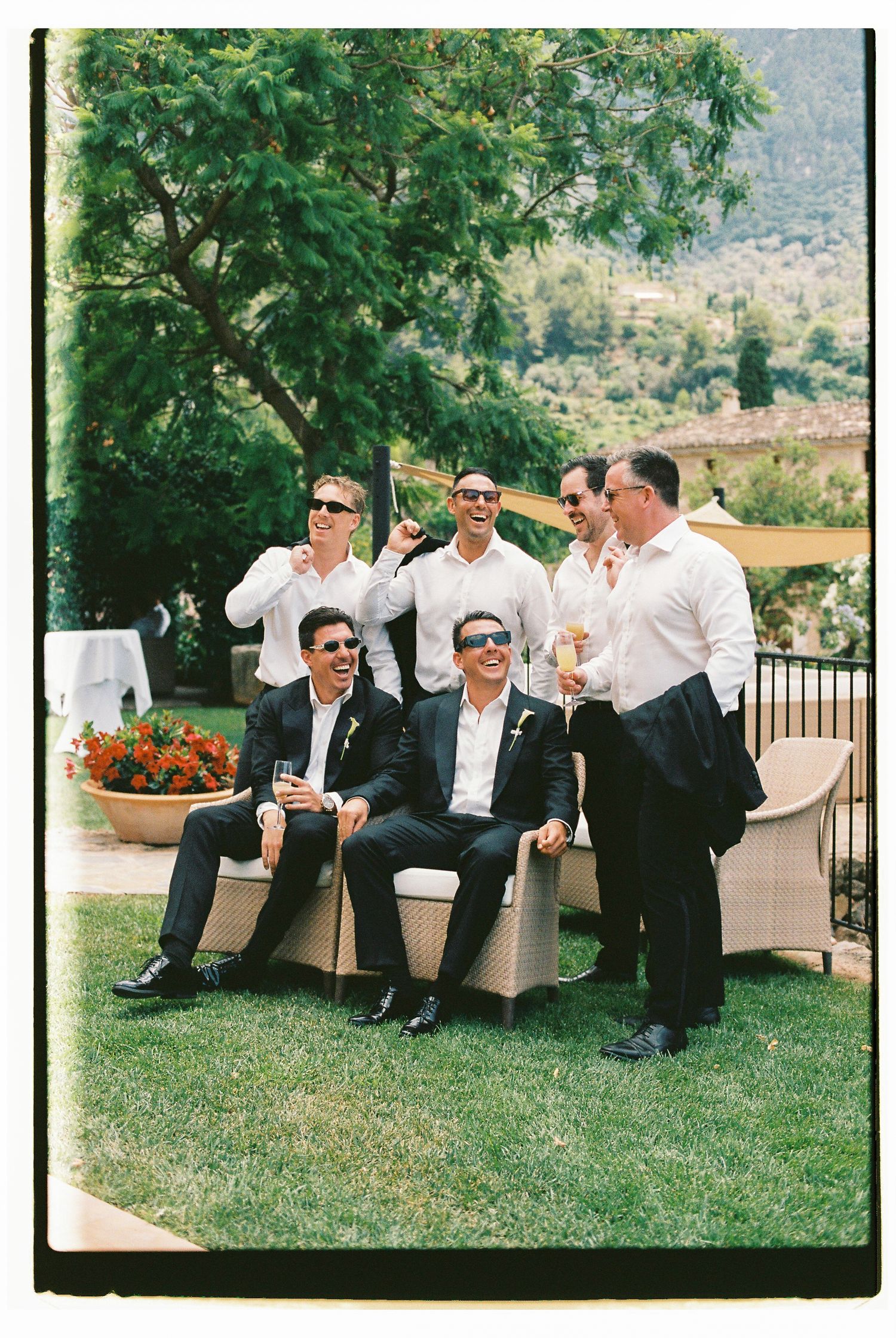 Group relaxing on outdoor furniture during sunny garden party.