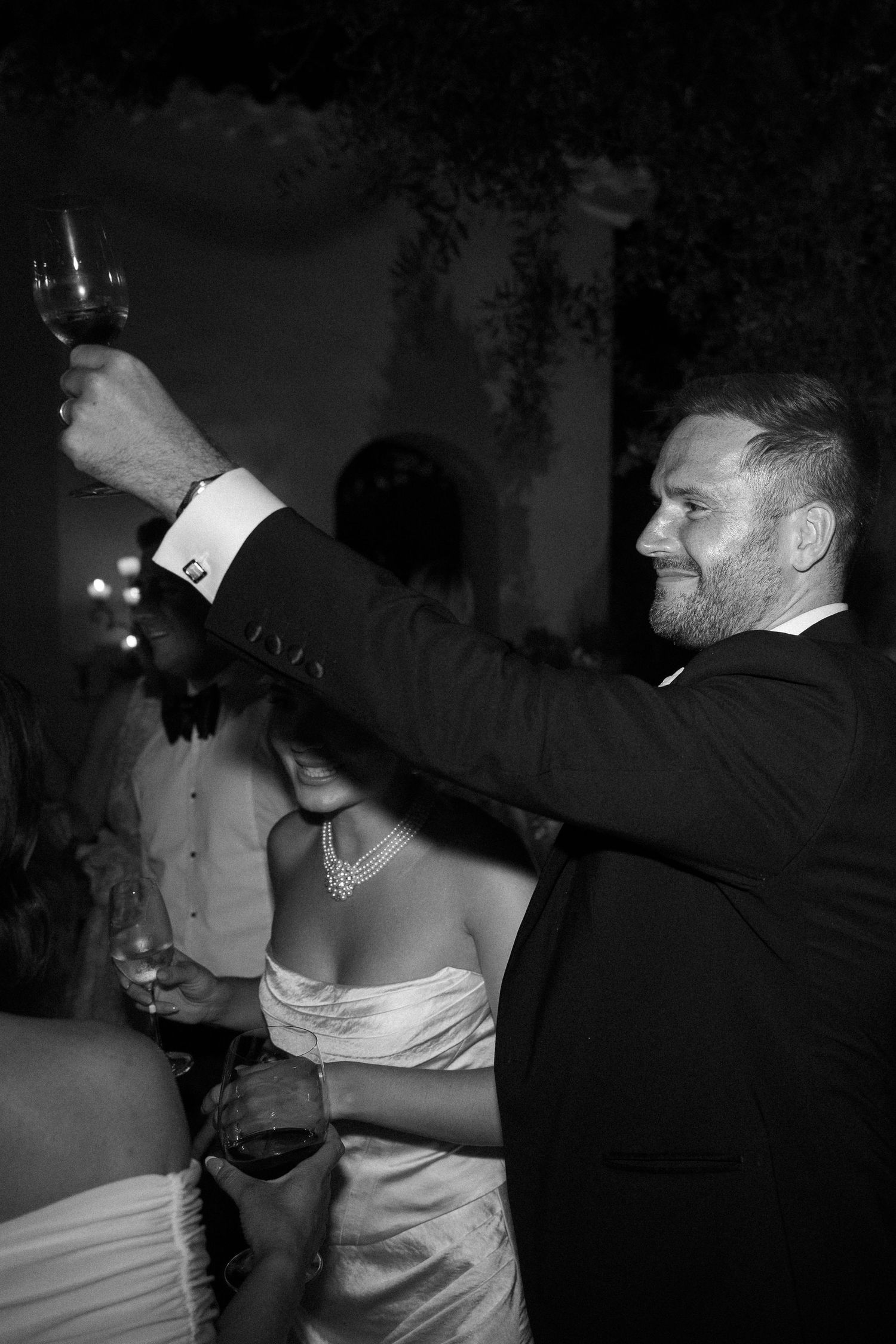 Wedding guests dancing and celebrating at an evening reception.