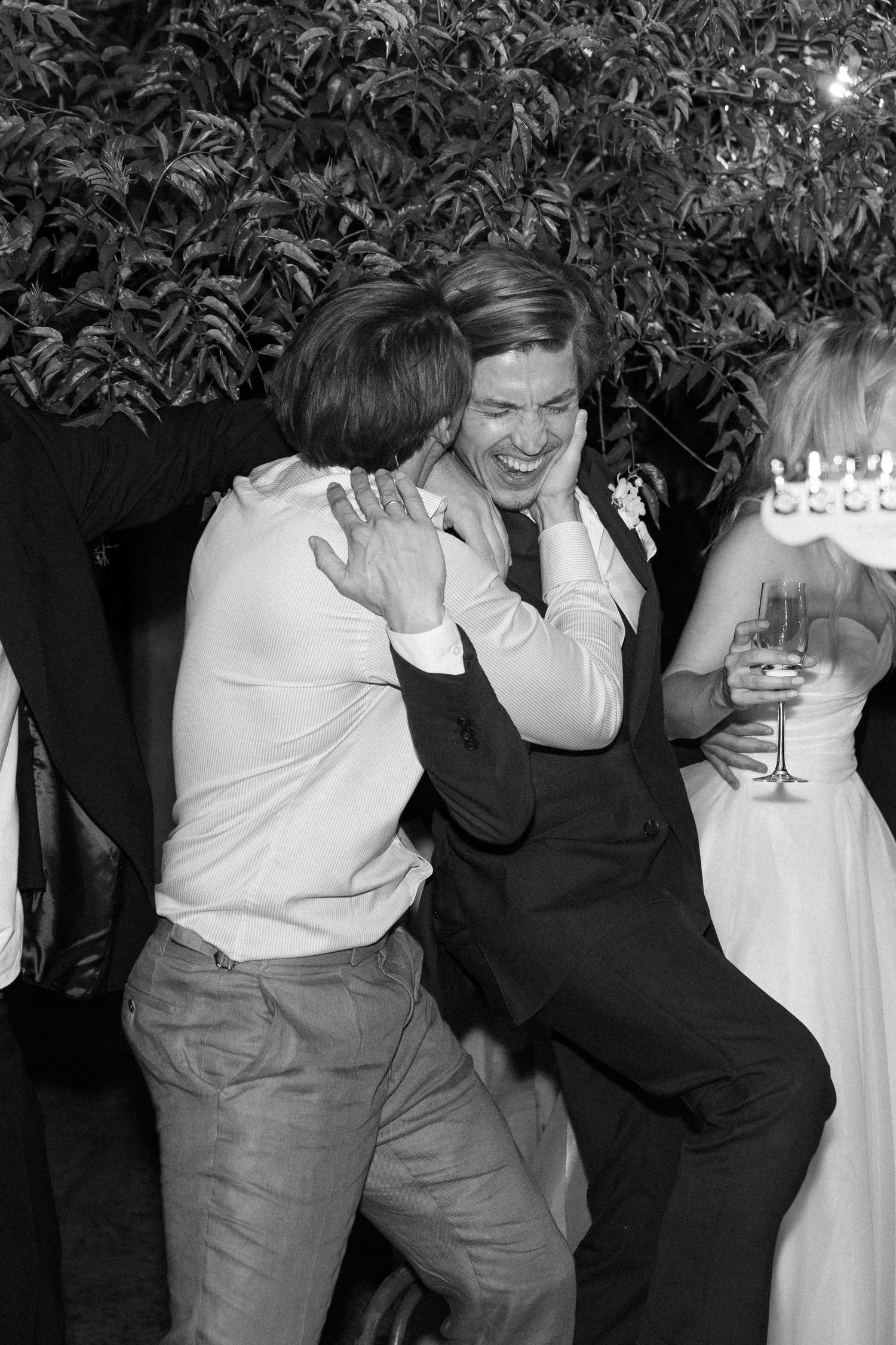 Candid black and white shots of wedding guests dancing and laughing.