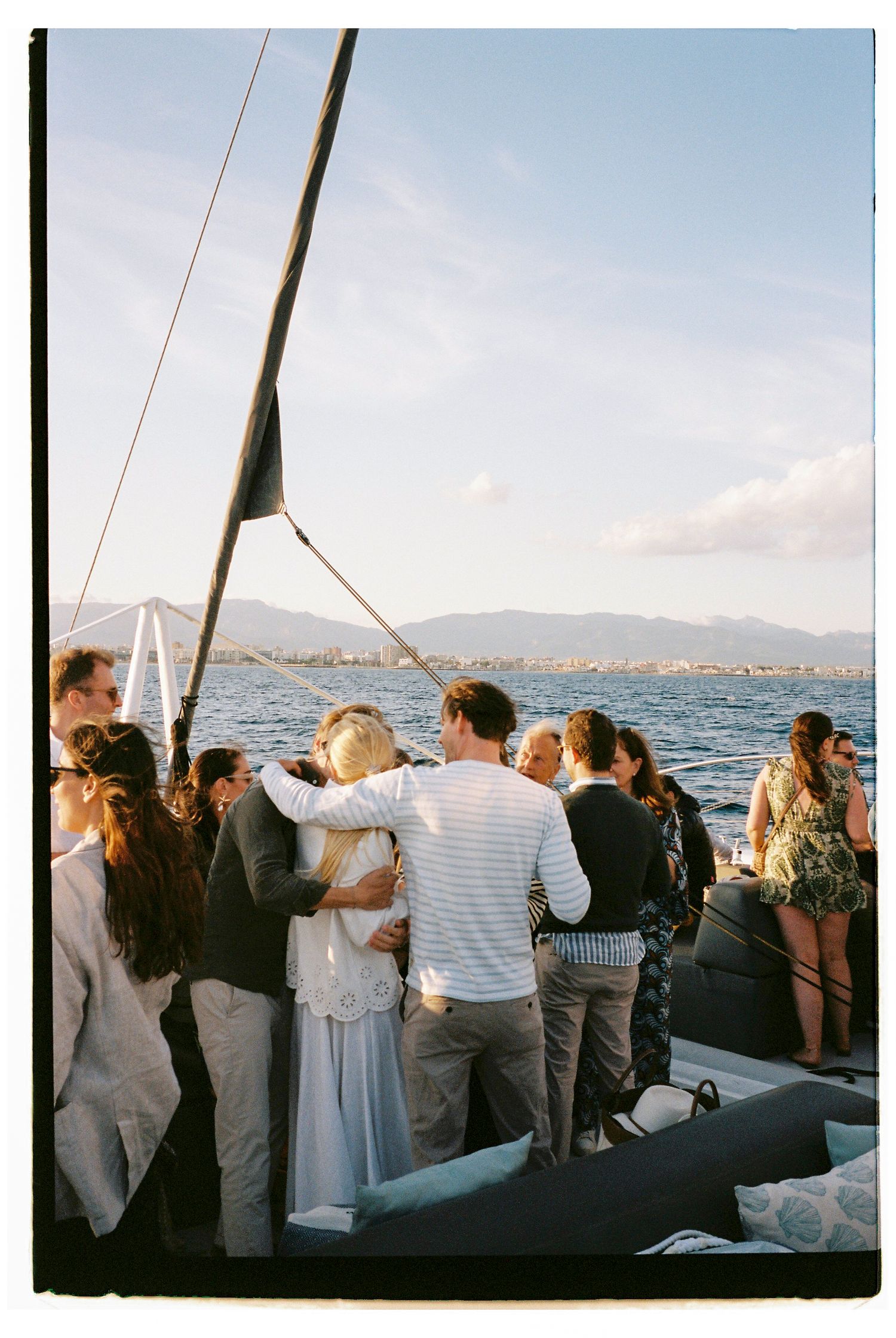 Guests gathered on deck of a sailing vessel enjoying an ocean view.
