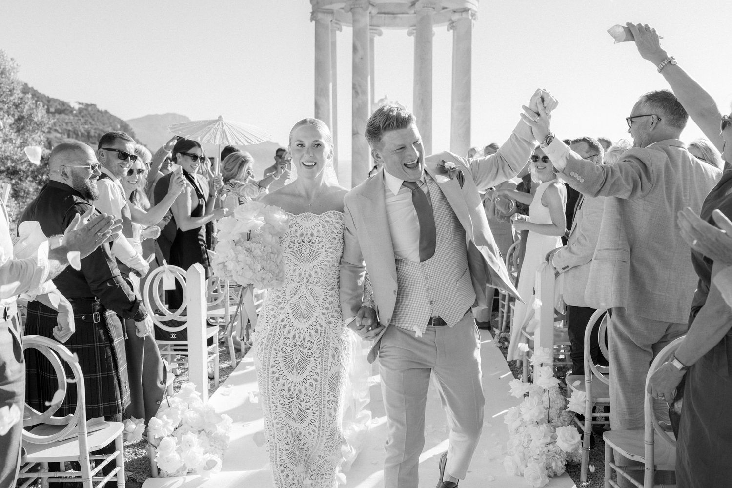 Black and white wedding ceremony photos showing guests celebrating at an outdoor venue.