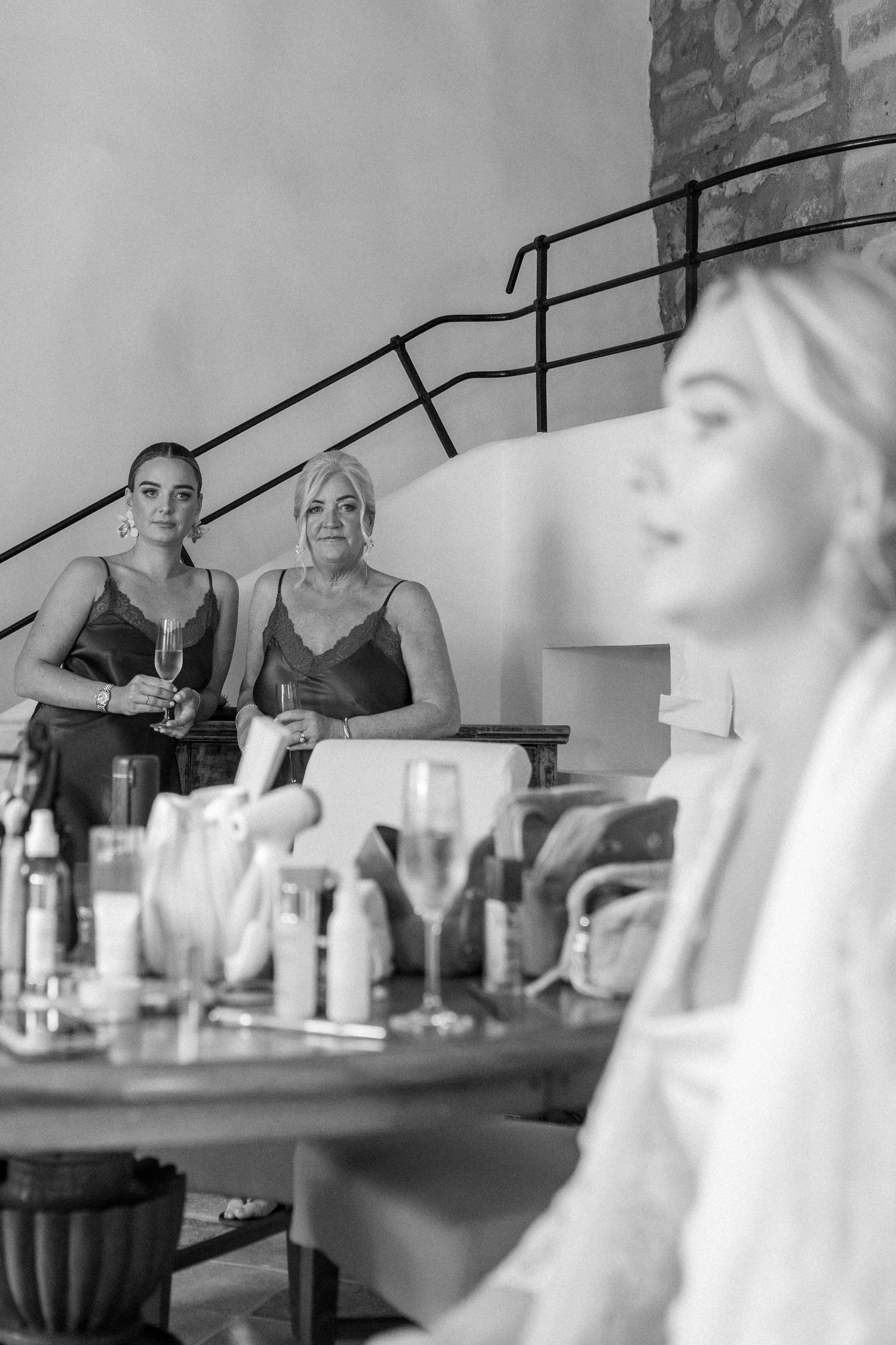 Wedding morning preparation scene with makeup products and styling tools on a table.