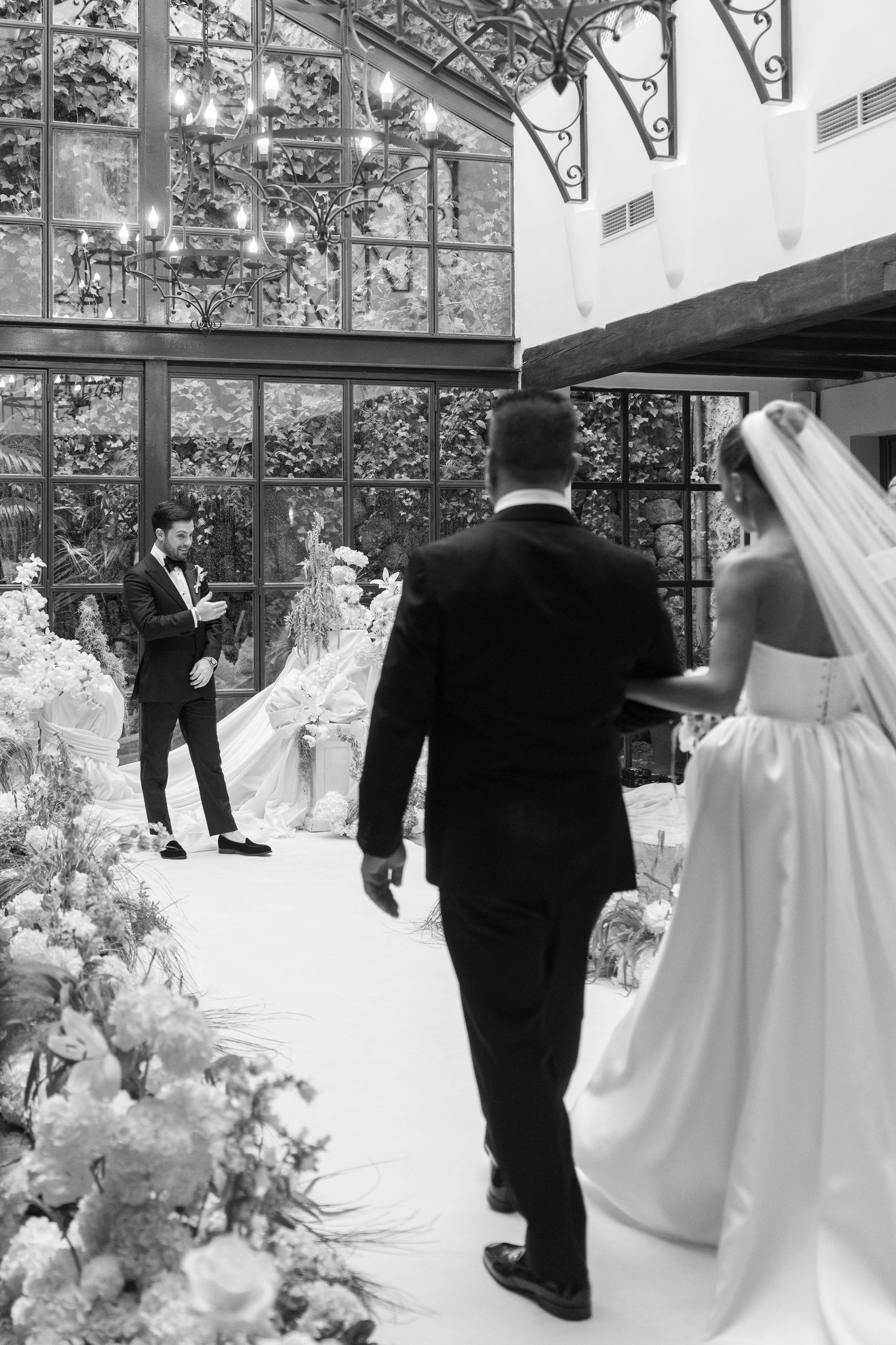 A black and white photo sequence shows a couple walking through an elegant wedding venue with floral decorations.
