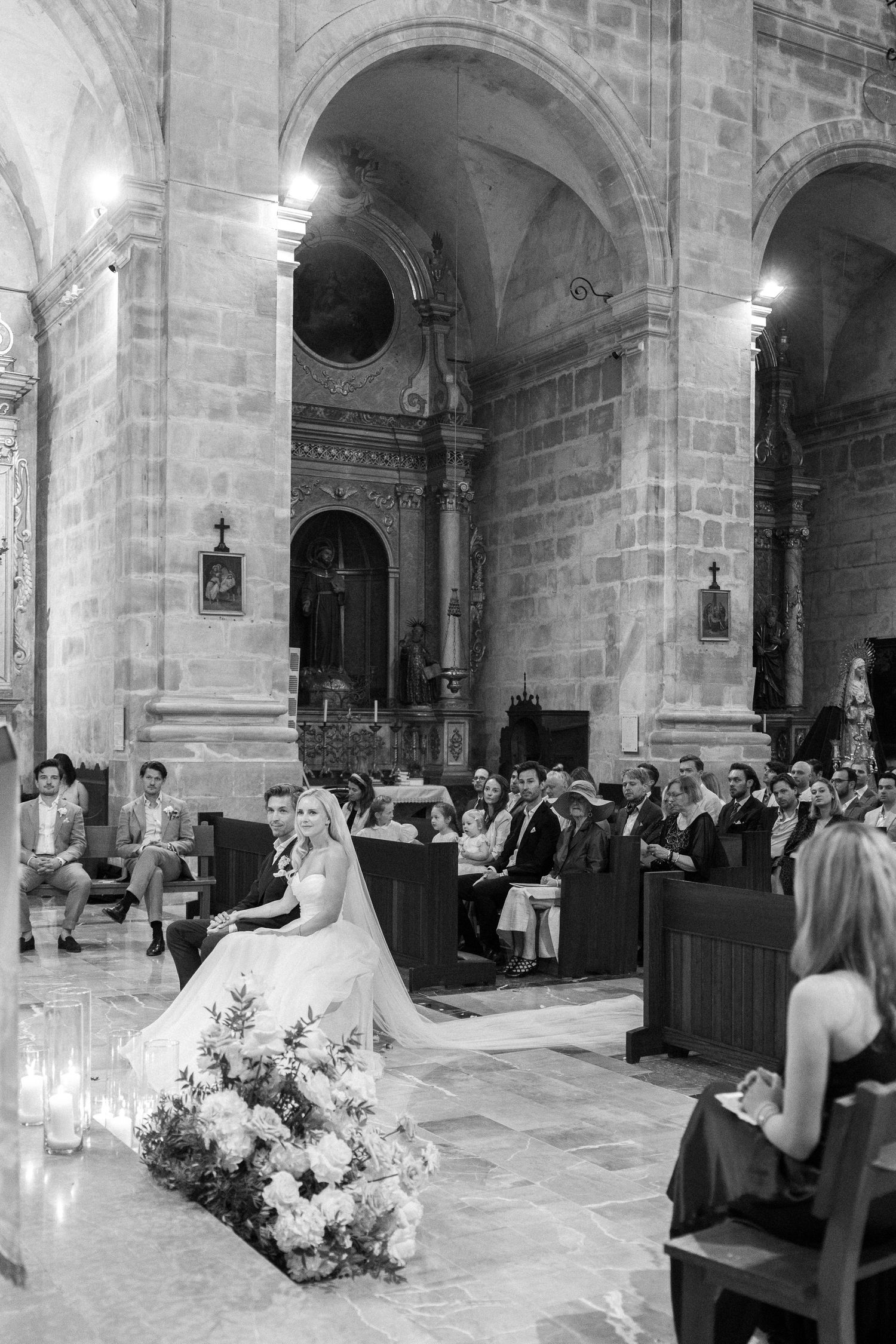 Wedding ceremony in a grand stone cathedral with vaulted ceilings and traditional architecture.