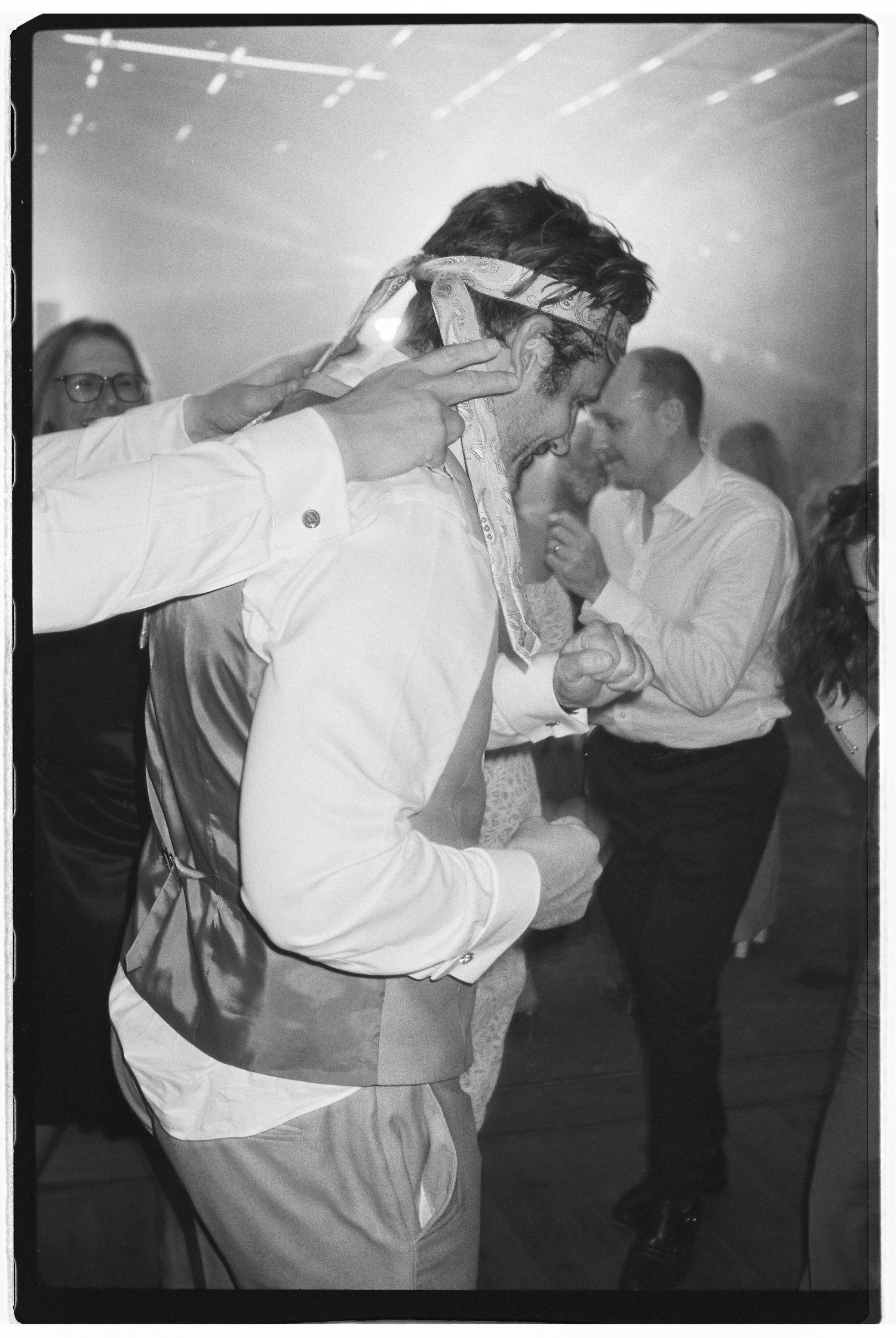 Black and white photos of couples dancing at a lively wedding reception.