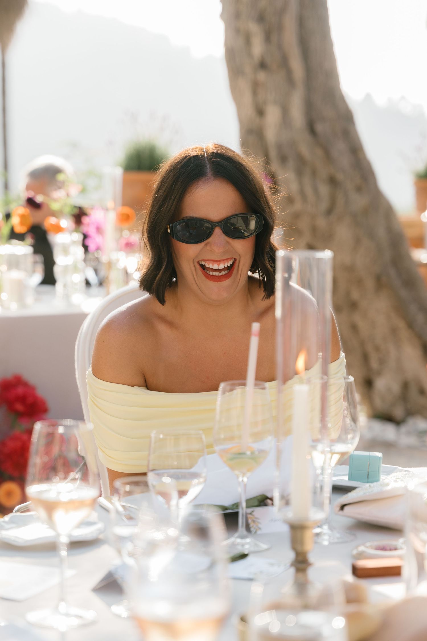 Guest enjoying a sunny outdoor wedding reception with elegant table settings.