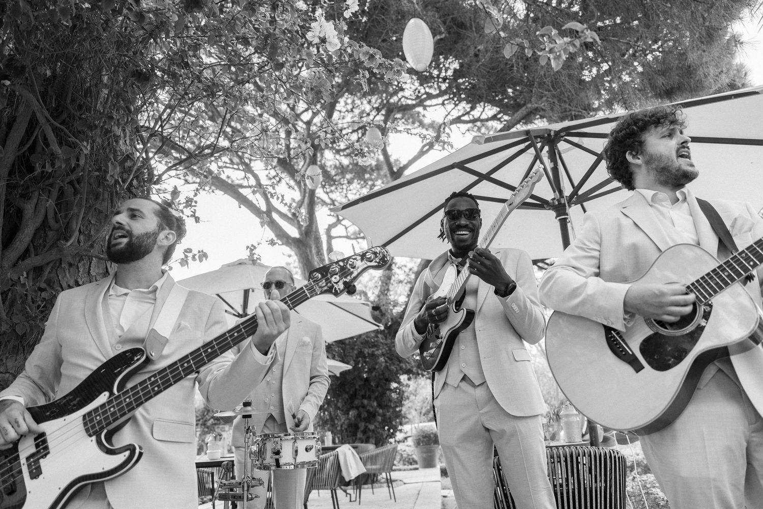Musicians performing with guitars at an outdoor garden celebration.