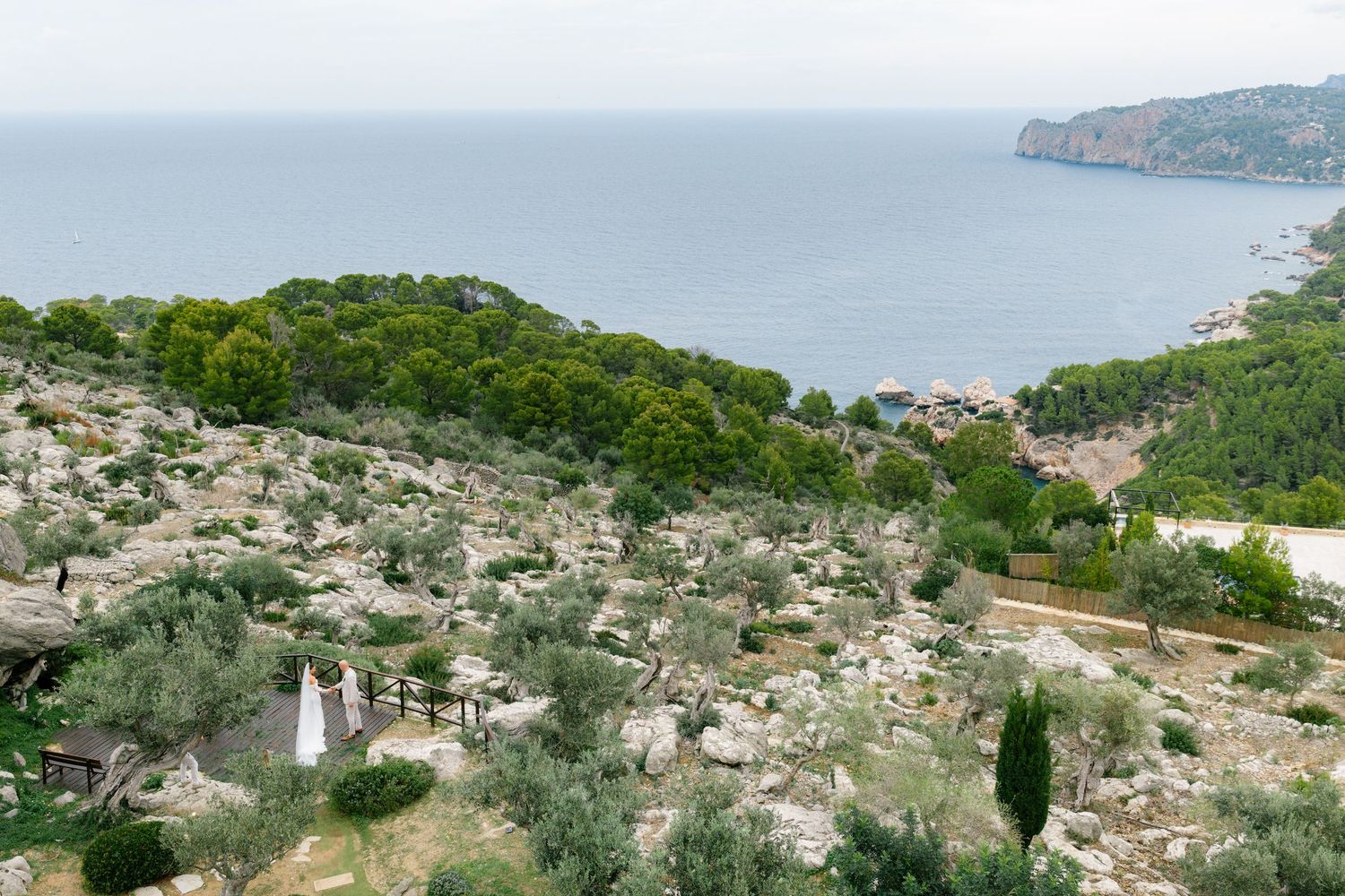 Panoramic aerial view of a coastal Mediterranean town nestled between mountains and sea.