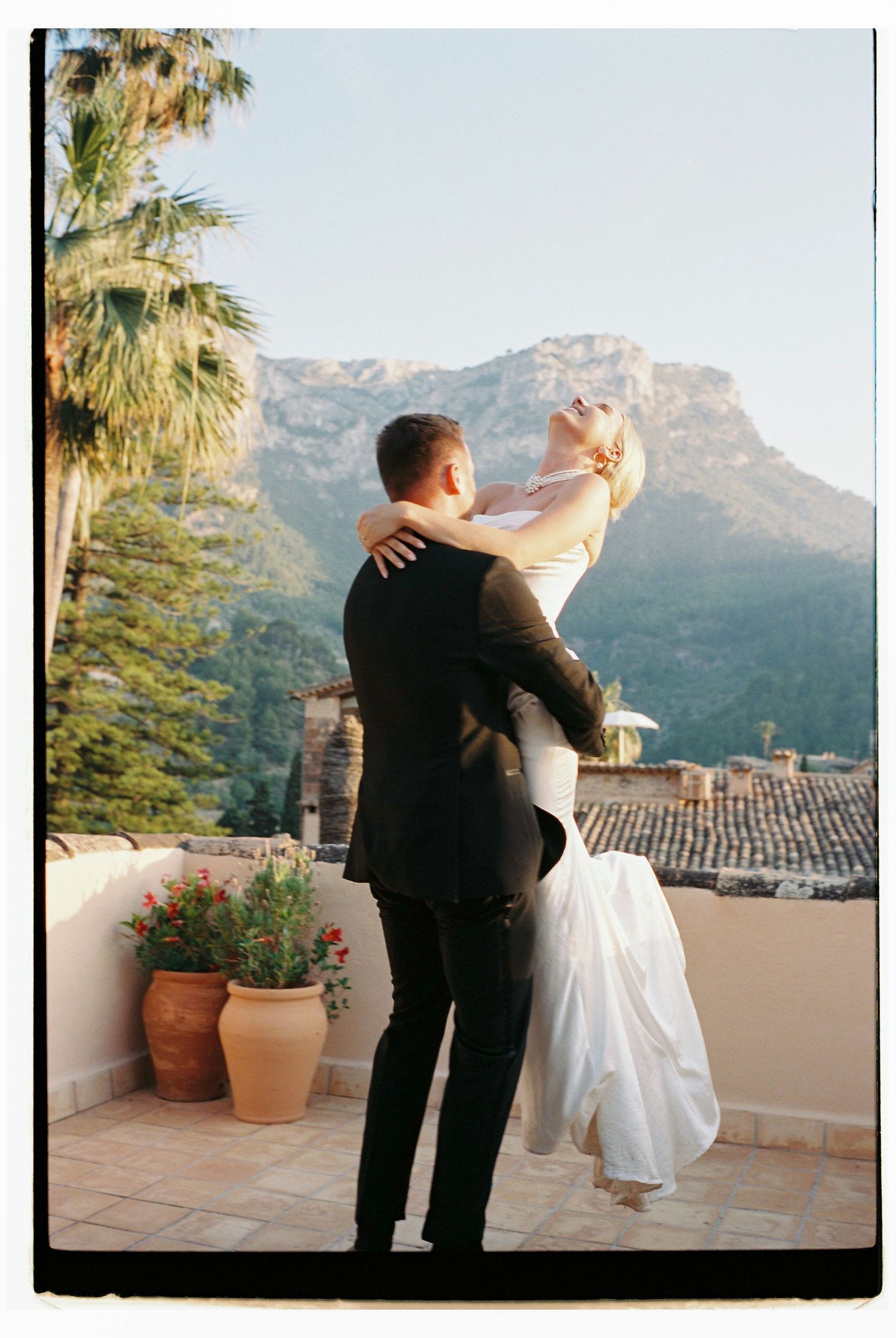 Romantic dance pose on a terrace overlooking mountains and Spanish-style rooftops.