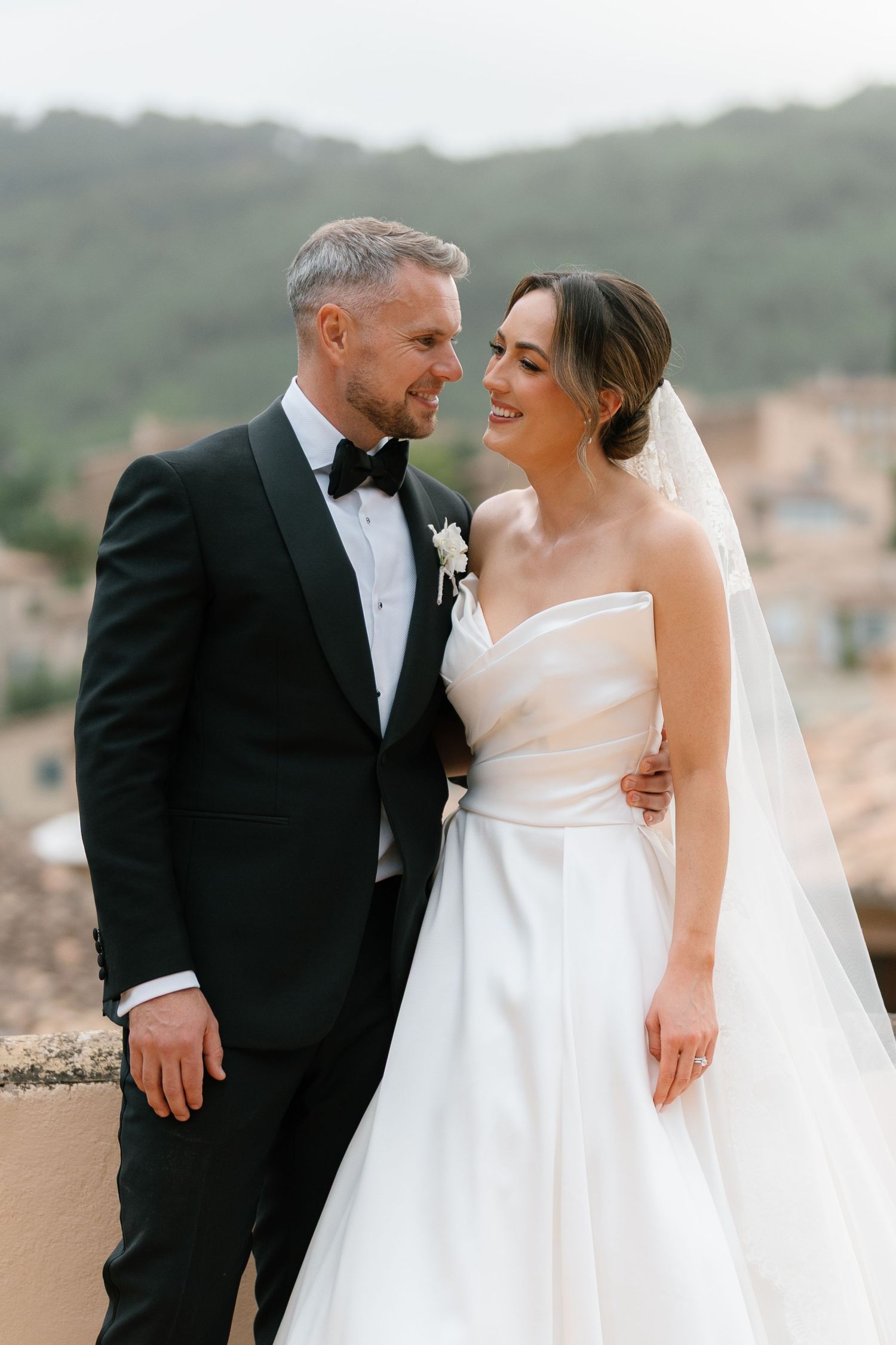 Wedding couple sharing an intimate moment on a terrace with mountain views.