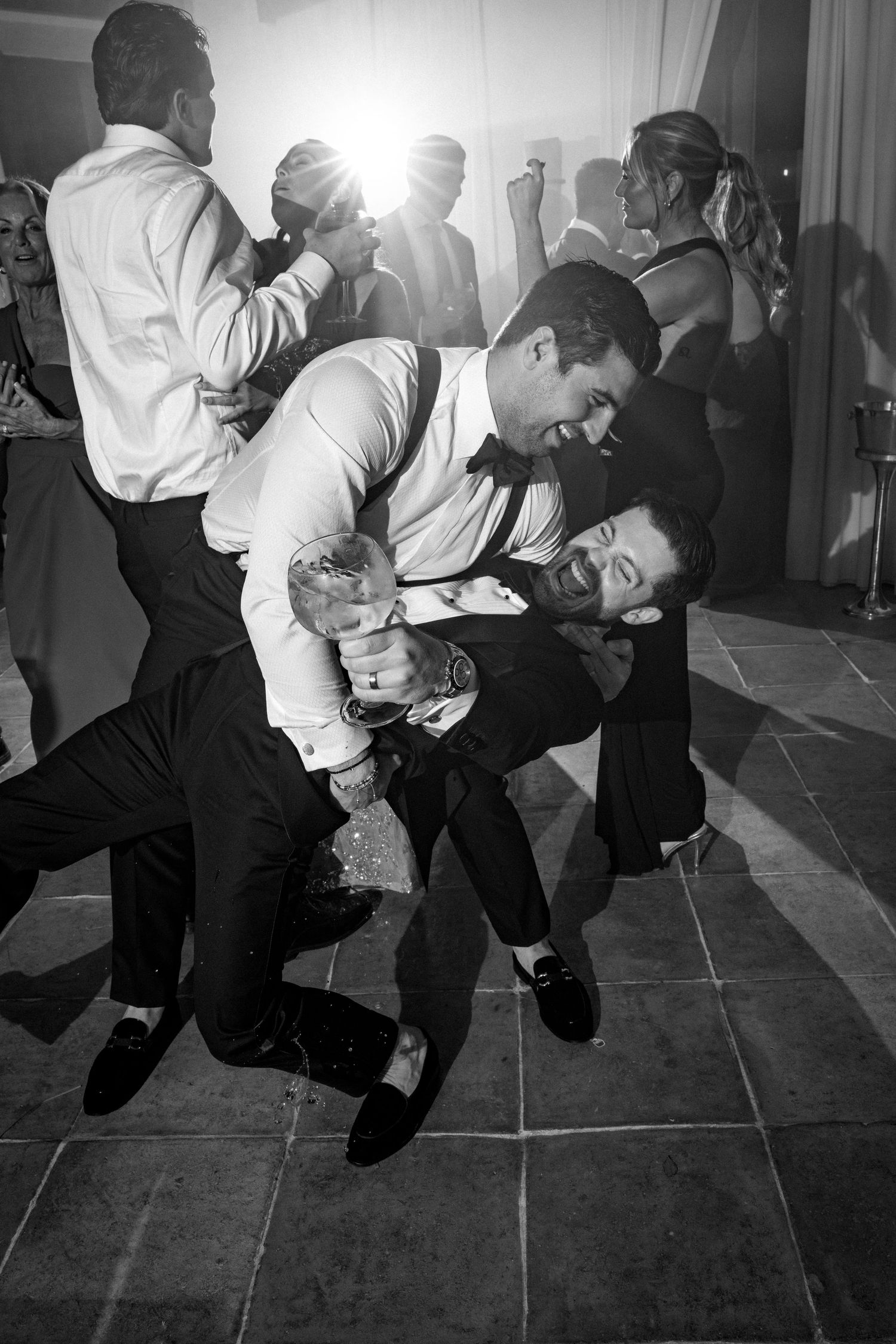 A sequence of black and white photos showing a person in formal attire performing dynamic dance moves on a floor.