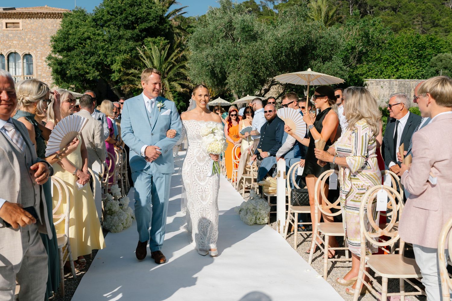 Wedding guests mingling outdoors at a garden reception venue.