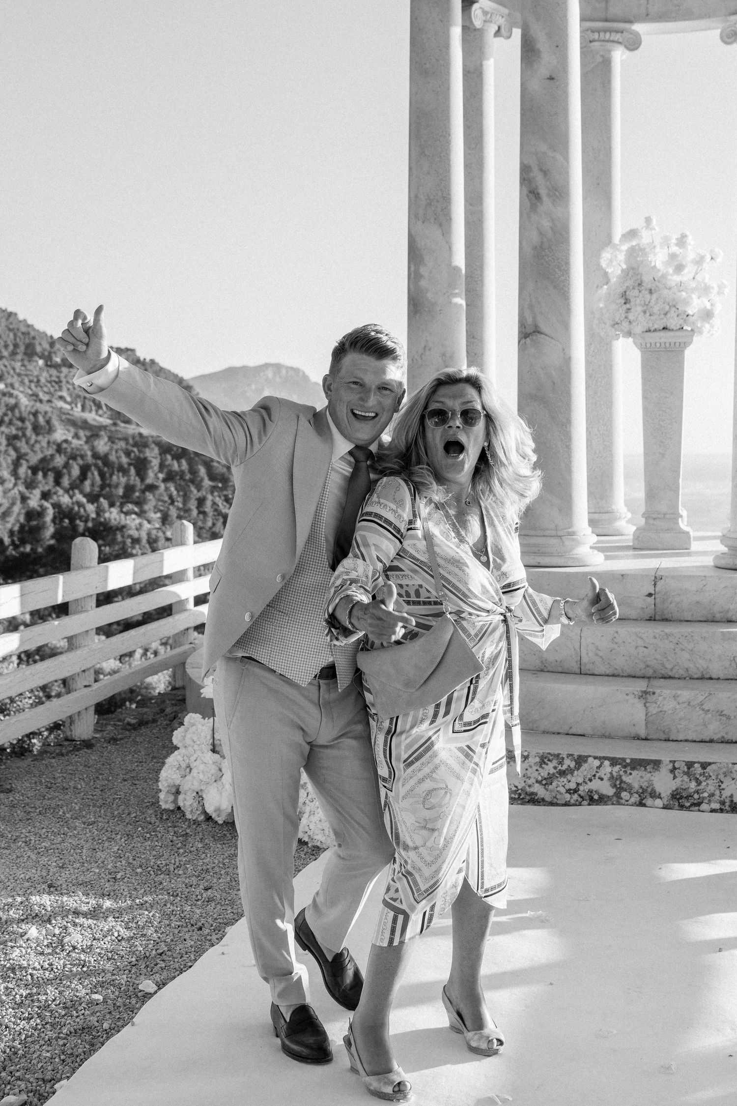 Black and white photo of joyful moments captured at a wedding gazebo.