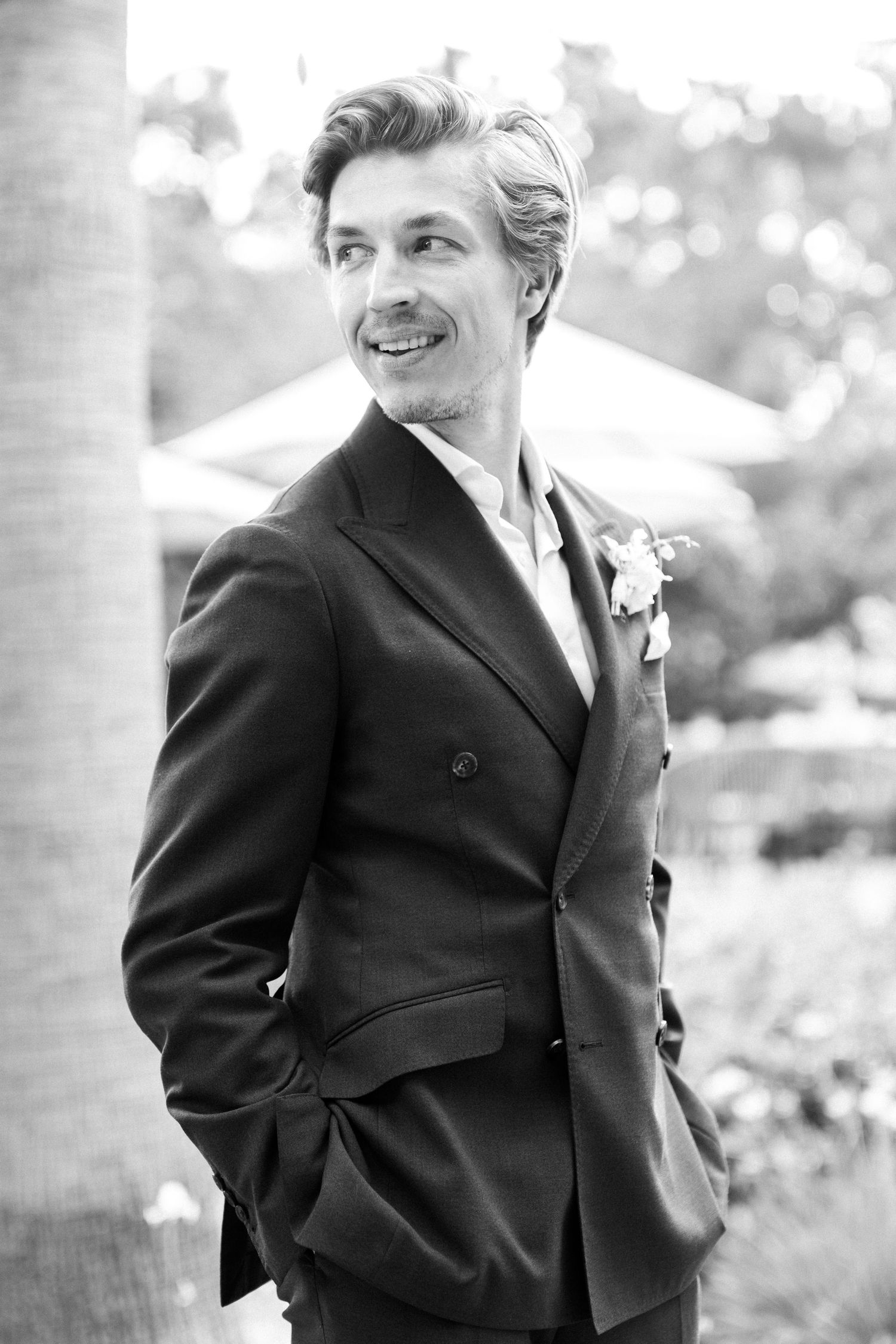 Person in formal black suit at an outdoor celebration.