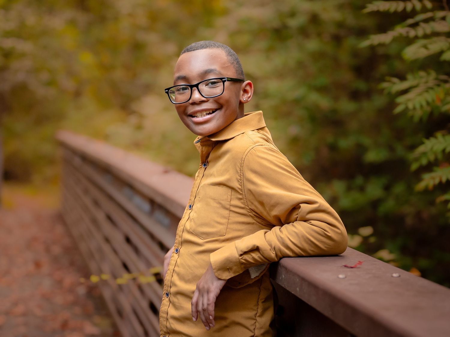 Smiling boy in mustard sweater during golden hour, Chesapeake VA child portrait photographer.