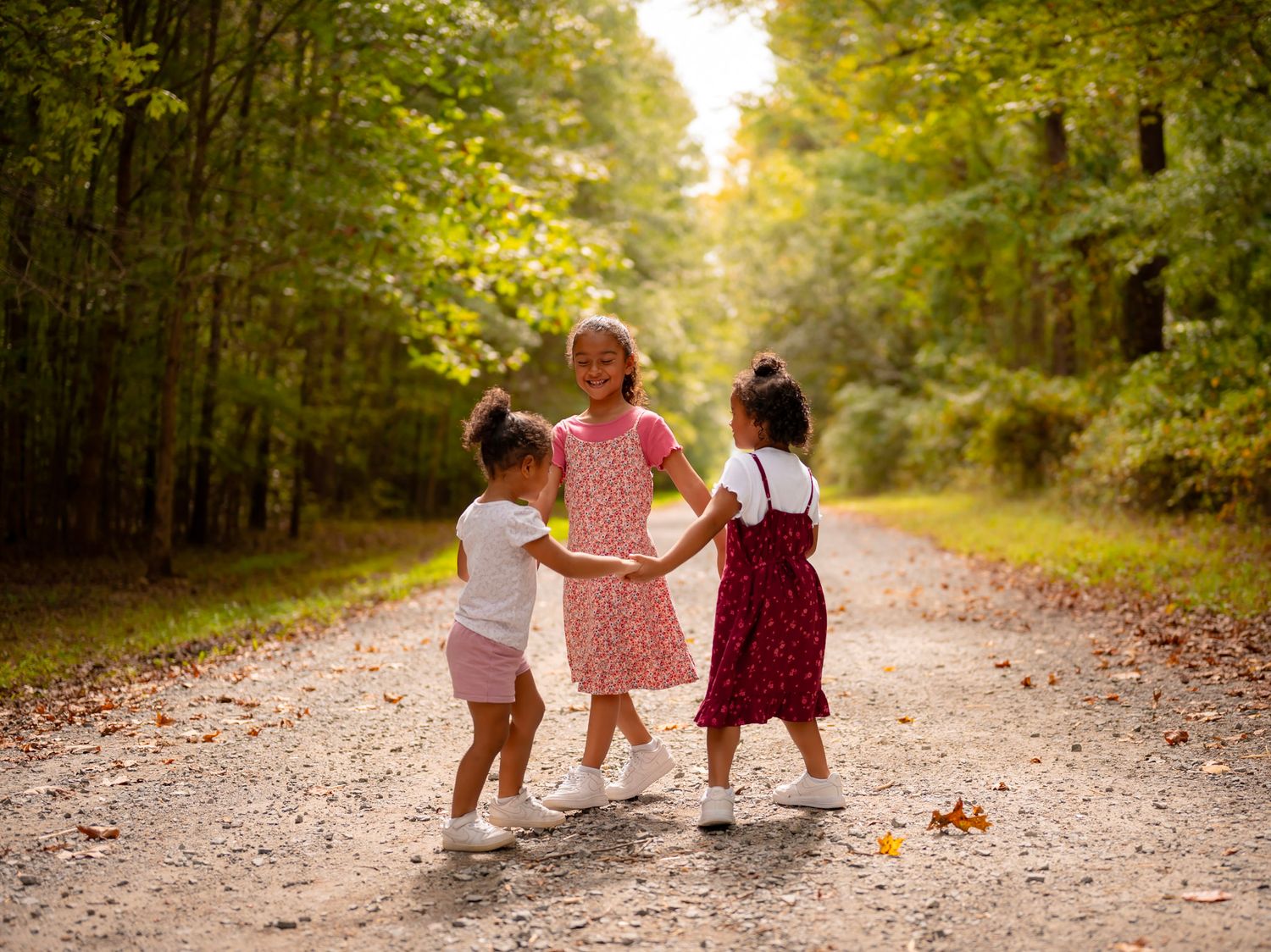 Sisters walking hand in hand on wooded trail, Chesapeake Virginia lifestyle photographer.
