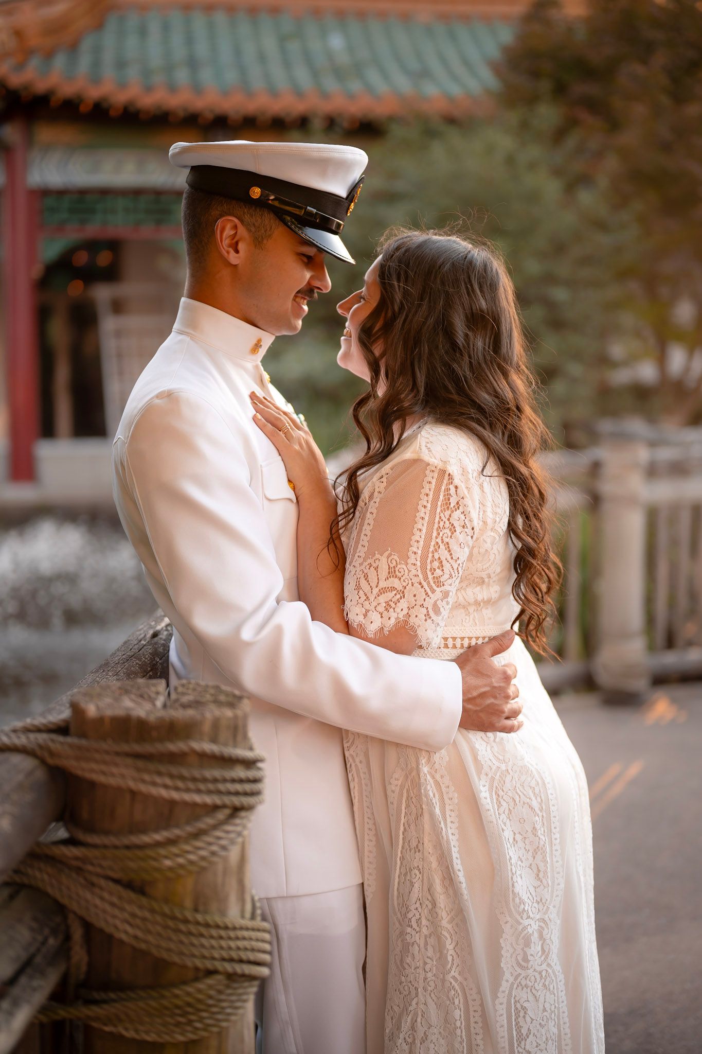 United States Navy couple embracing in sunset light in Pagoda Oriental Gardens in Norfolk, VA.