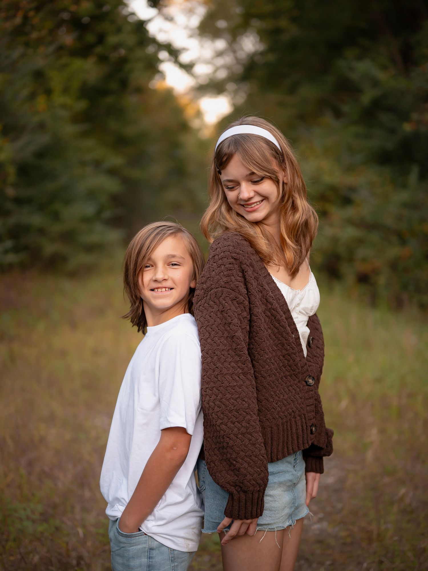 Brother and sister smiling together in golden light - moody outdoor family portrait session by Photography by Kylee Mason.
