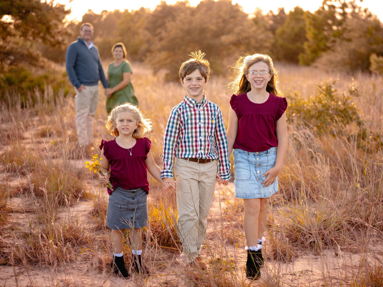 Family walking through golden field during sunset, Chesapeake VA outdoor portraits.