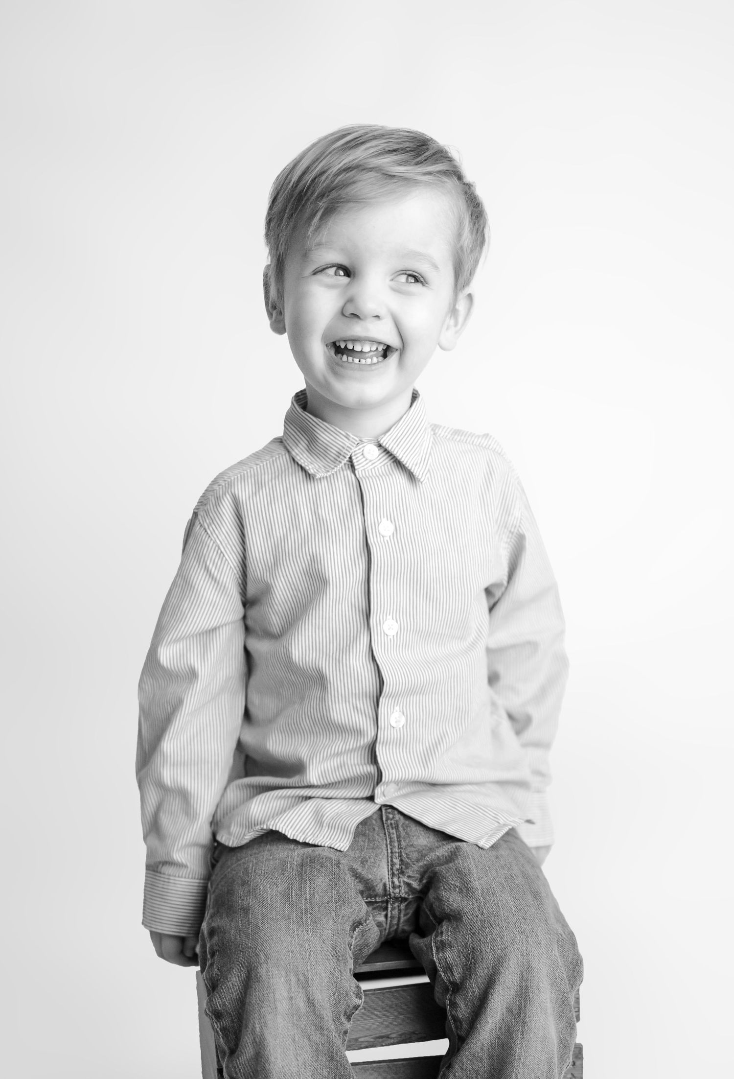 black and white photo of toddler boy against a white backdrop