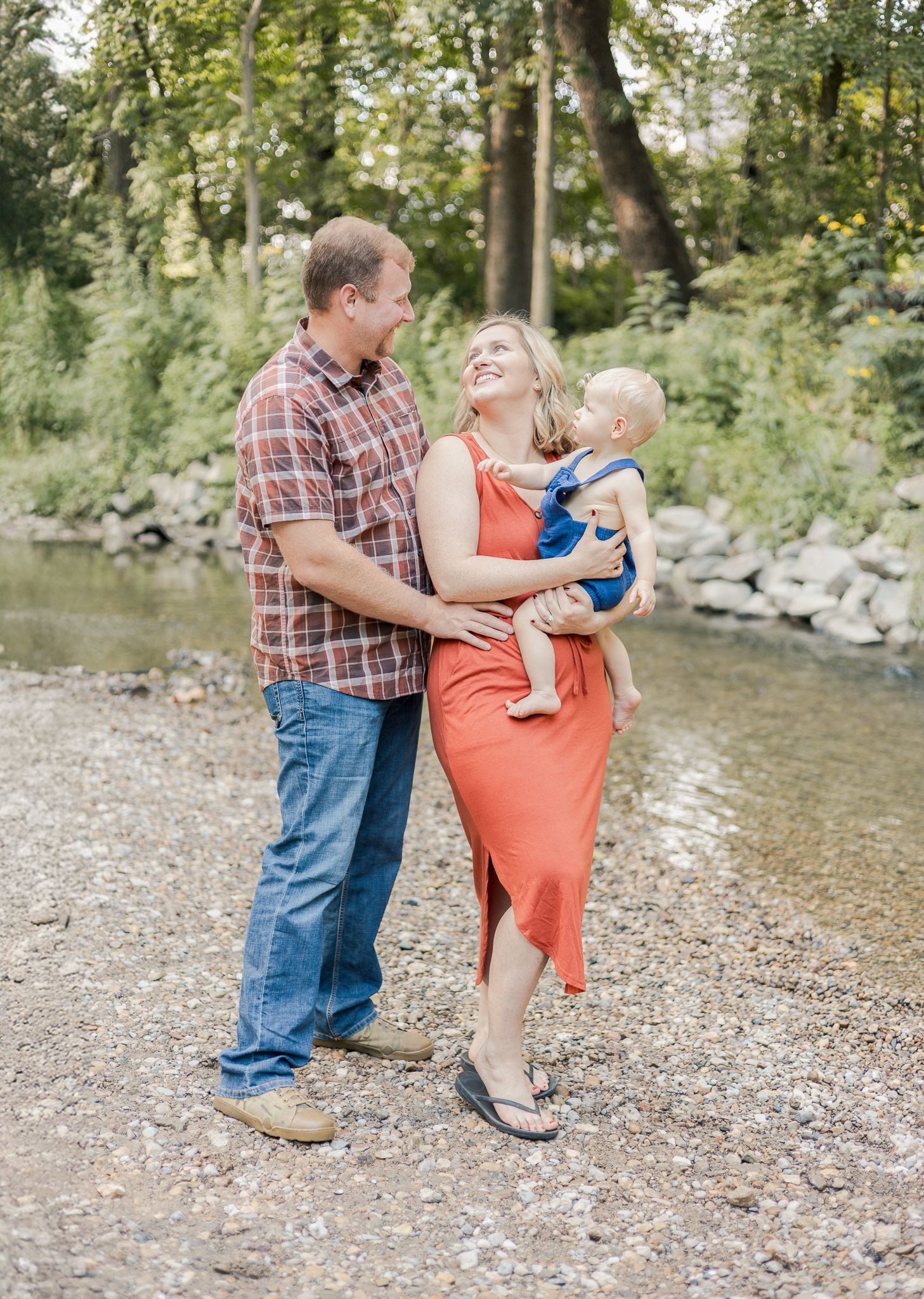 dad and mom looking lovingly at each other while she is holding the baby on her hip