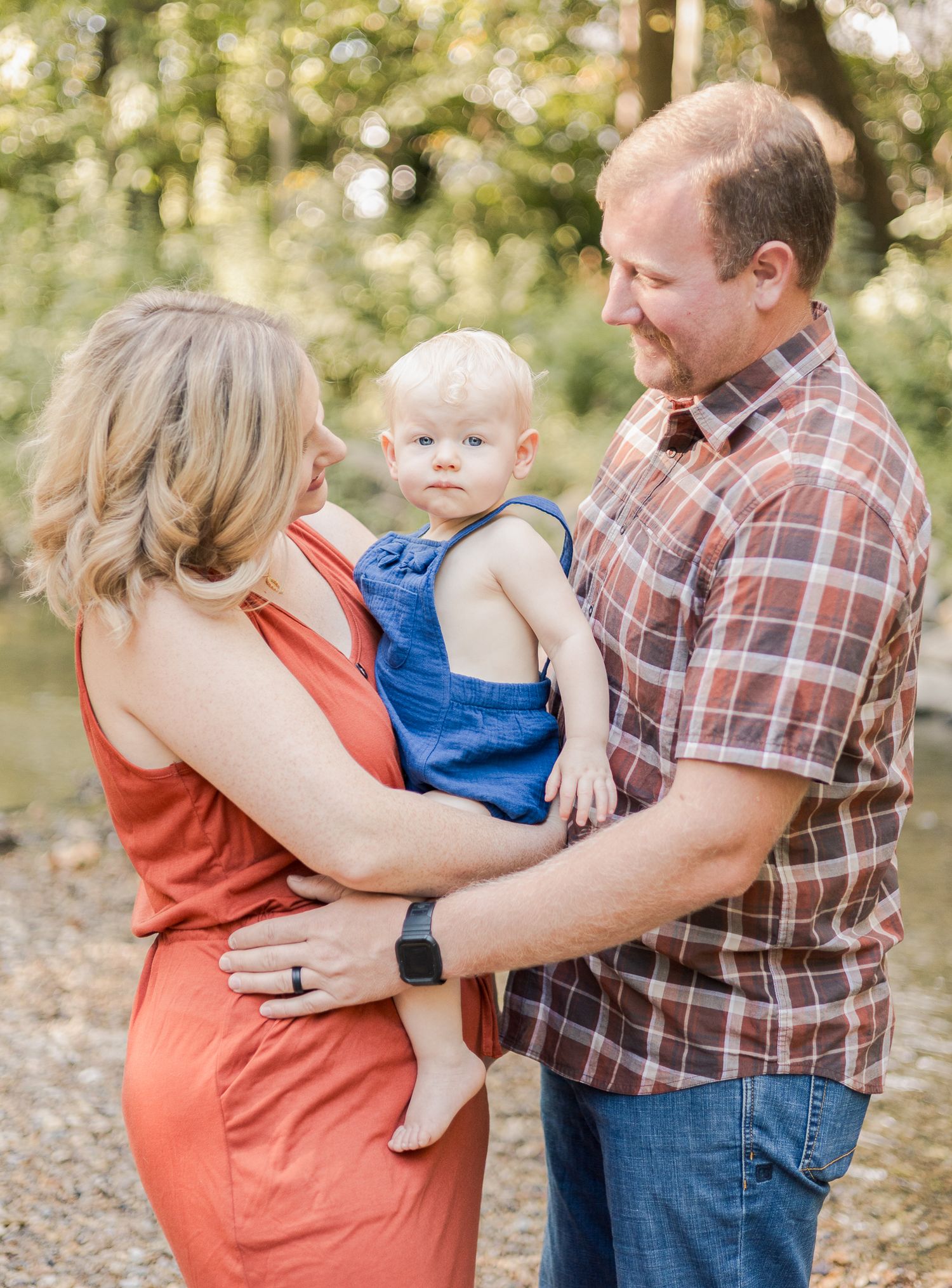 mother holding son while father holds the mom, son is between