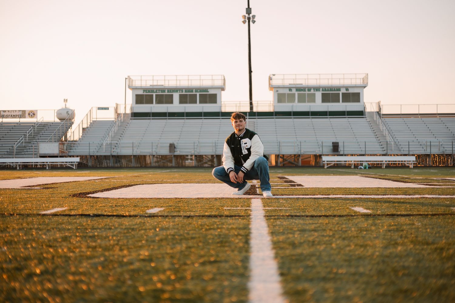 senior on a football field crouched down