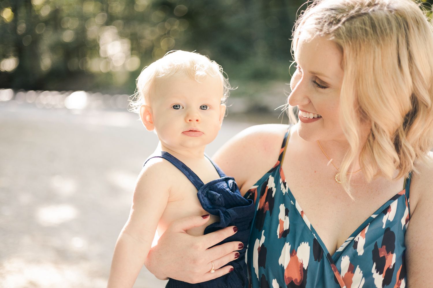 mother looking at baby while smiling, a creek in the background